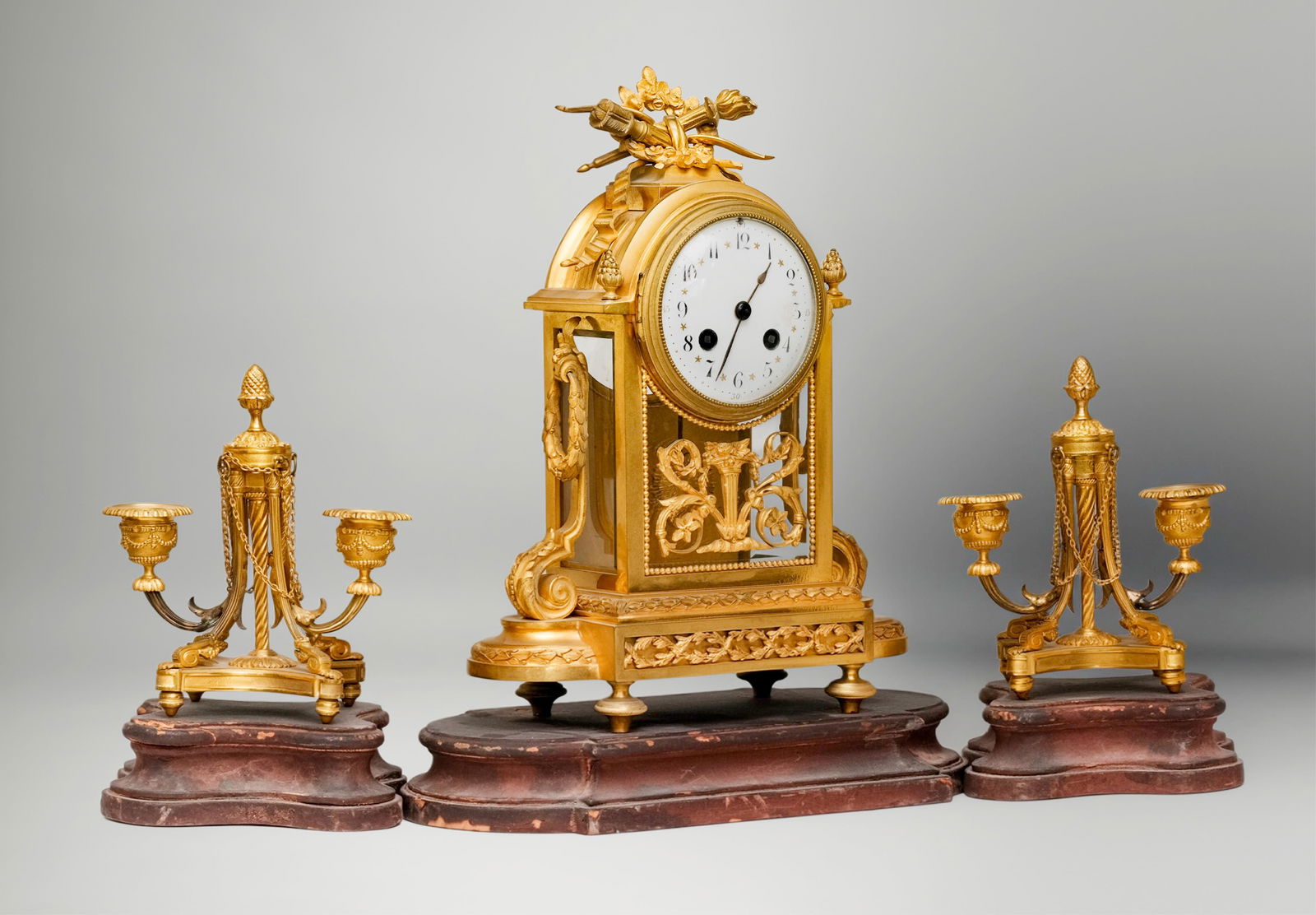 French Empire Period Garniture Clock Set, Antique Dore Gilt Bronze19th Century: Keywords: French bronze, mantel clock, French Empire, gilded bronze, floral motifs, classical scrollwork, 19th-century craftsmanship, white enamel dial, Roman numerals, horology Summary: Fine antique