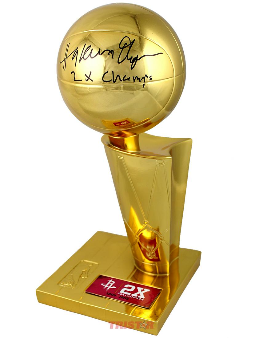 Hakeem Olajuwon Autographed NBA Championship Trophy: Hakeem Olajuwon signed Replica NBA Championship Trophy Inscribed: 2 X Champs. Prestigious authenticity from industry expert TriStar Productions included (with hologram).