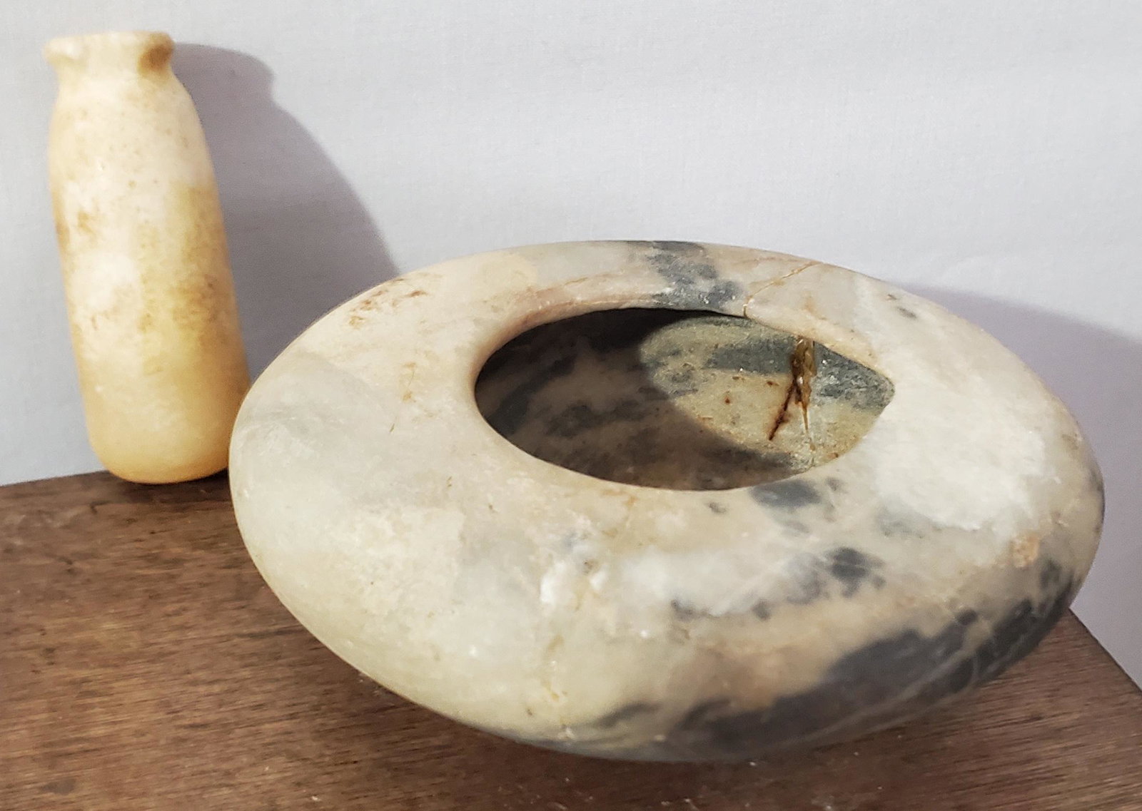 Two Ancient Egyptian Stone Vessels: Two early Ancient Egyptian carved stone vessels, a cylindrical perfume bottle and a squat round paste (?) container, early 2nd millennium BC.