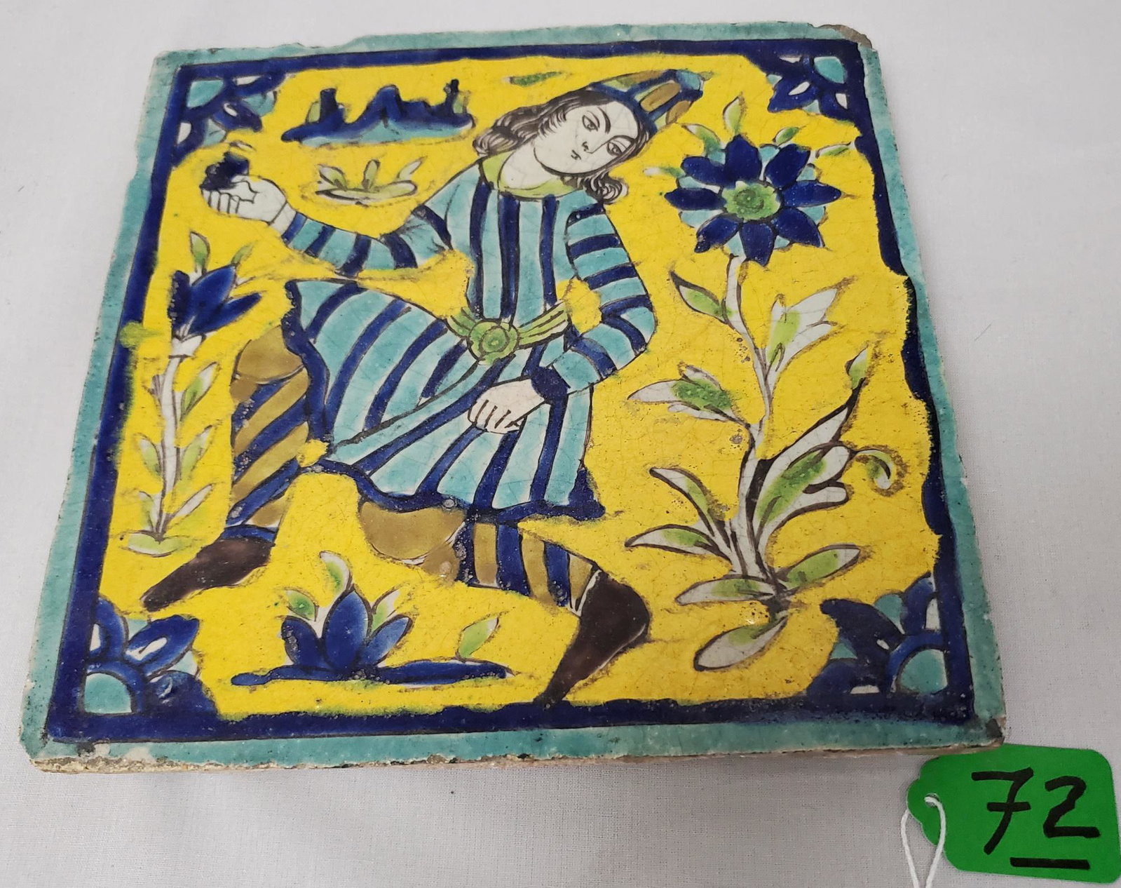 Safavid Persian Tile: A good Safavid Persian tile of a youth picking flowers in a yellow field 8 x 8 inches