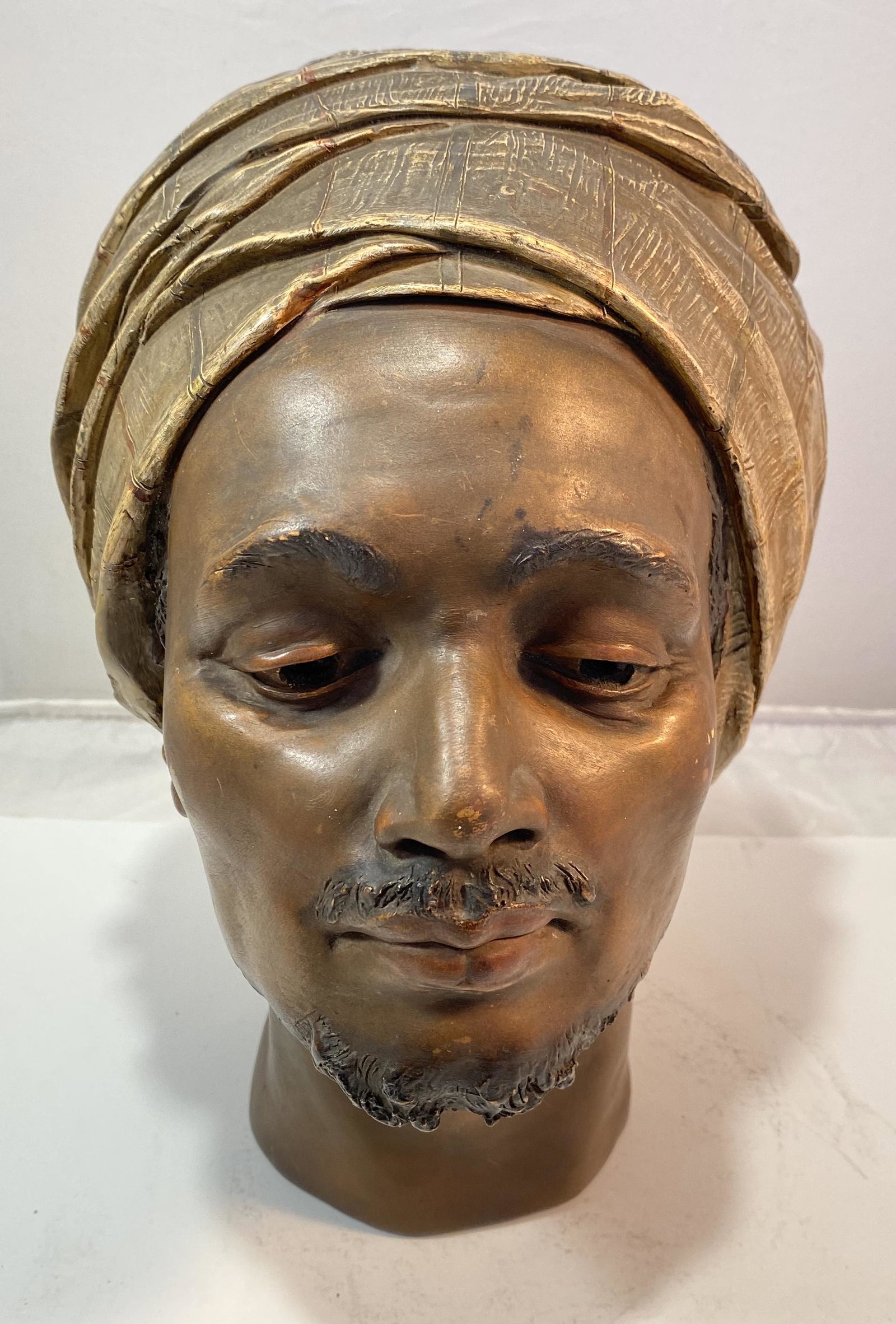 Figure of Head of North African: A handsome and very decorative Head of a North African or Middle Eastern Man with downcast eyes, realistically sculpted and painted, terra cotta or plaster. 10 tall x 8 1/2 x 7