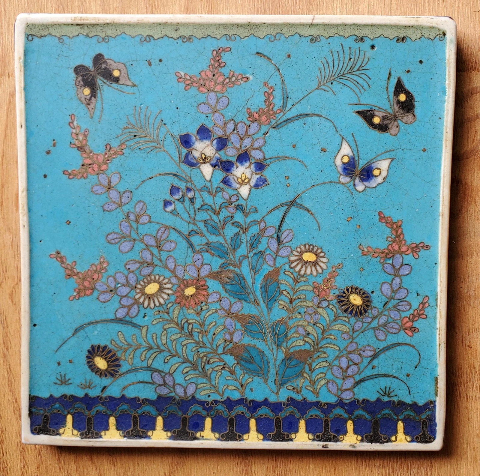 Japanese Cloisonne Tile: Japanese Porcelain Cloisonne Tile. Very unusual and rare shape with a flowering bush and three butterflies, Meiji Period. 5 7/8 in. x 5 7/8 in. approximately and 3/8 in. thickness.
