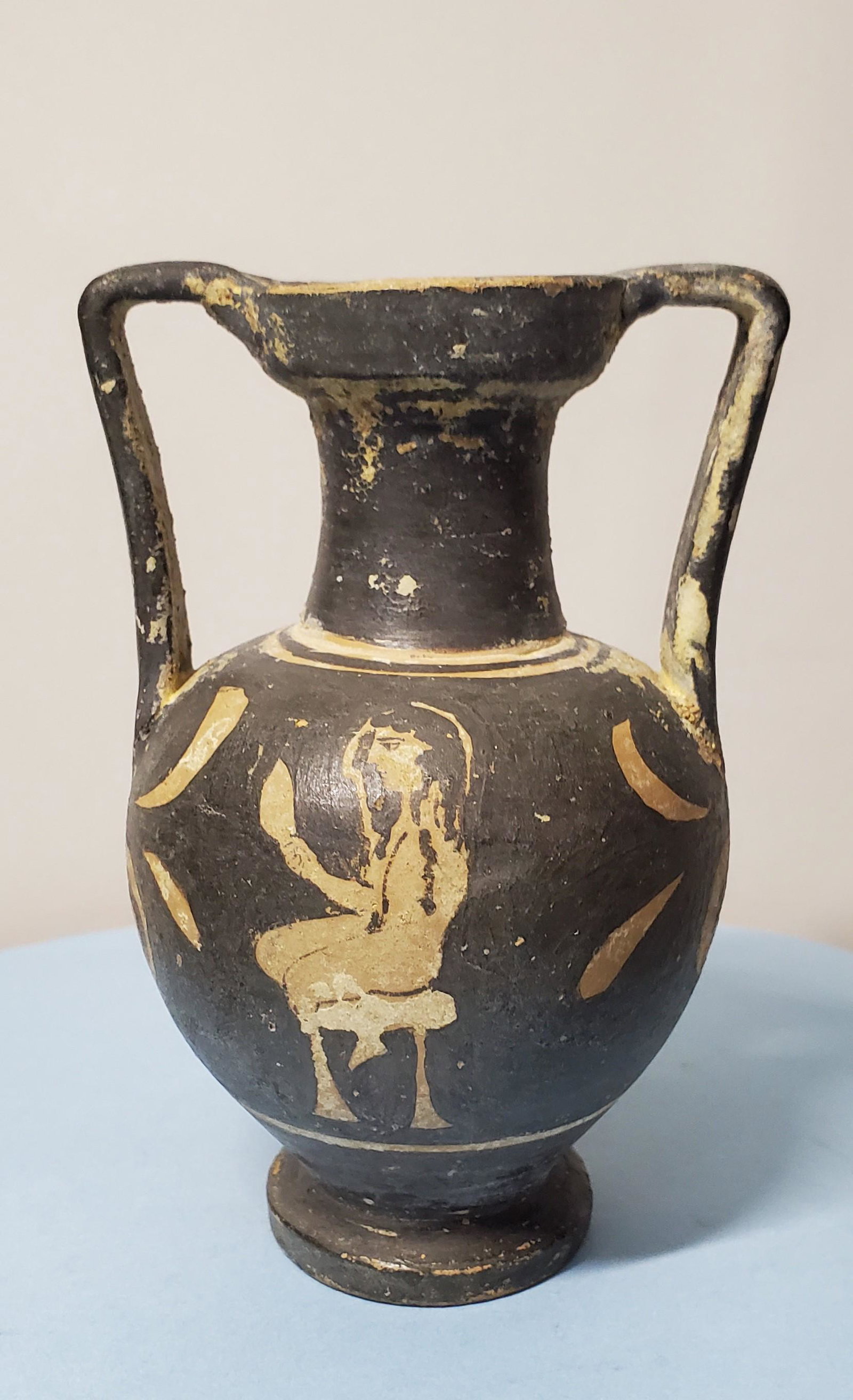 Red Figure Amphora: Ancient Red Figure Amphora. An ancient Apulian Greek red figure, small amphora with the head of a young man and a young woman seated on a stool and holding an object, 4 th Century BC. 4 7/8 in. x 3 1/