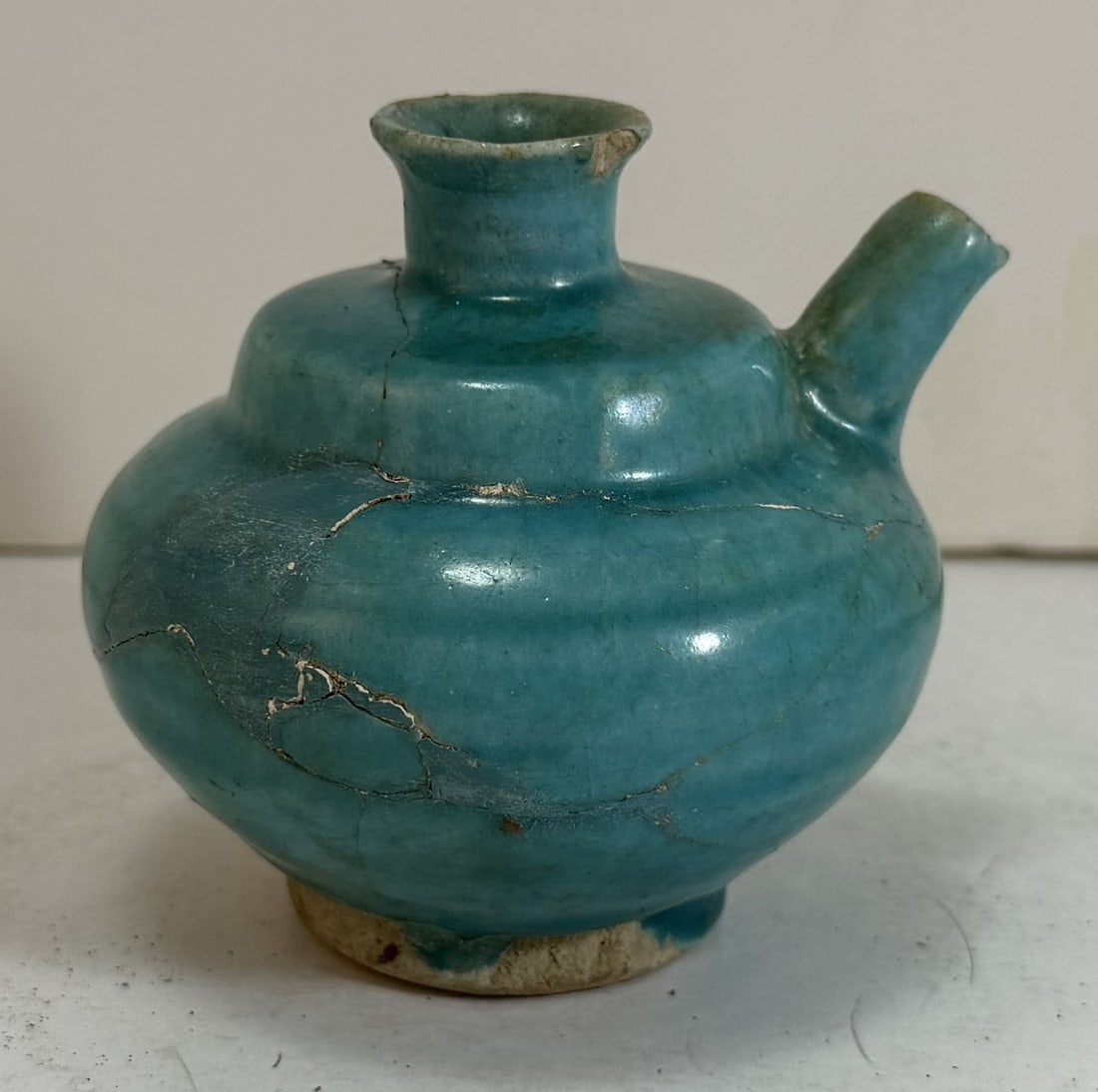 Persian Turquoise Glazed Ceramic Spouted Vessel, 12th / 14th Century: With a chip on the lip and repairs. Height: 3 1/4 inches, 3 1/2 inches wide at the spout. Weight: 5.2 oz.