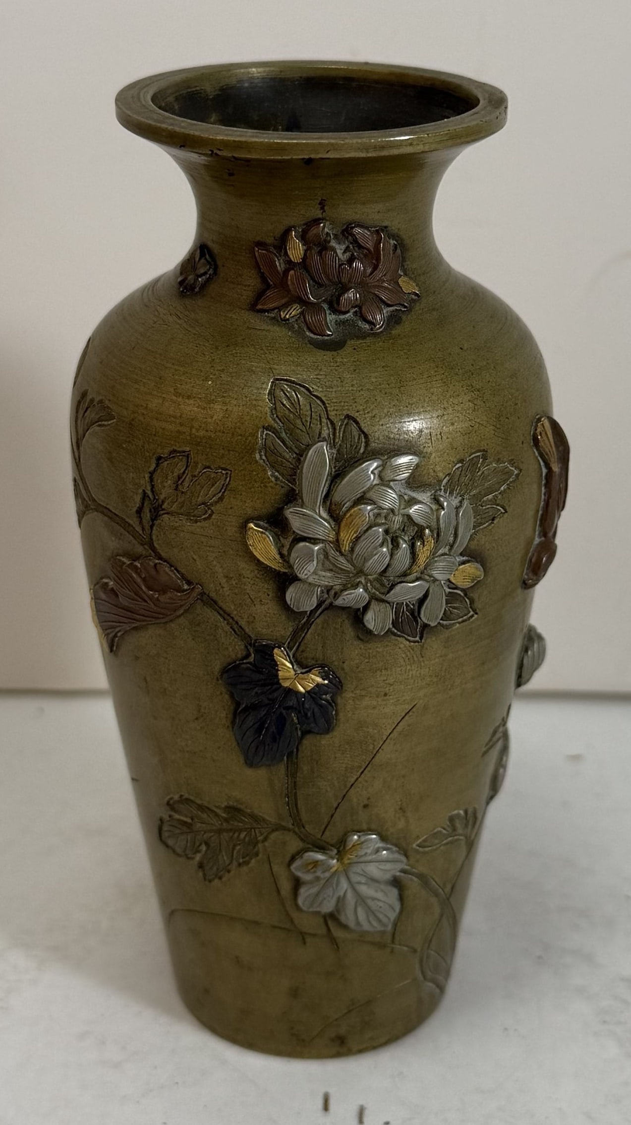 Japanese Mixed Metal Baluster Vase, Meiji Period: A patinated bronze vase with inlaid gold, silver, and copper chrysanthemum blossoms, leaves and a bird in relief and with stems and leaves engraved. Height: 5 inches, Diameter: 2 1/2 inches at the