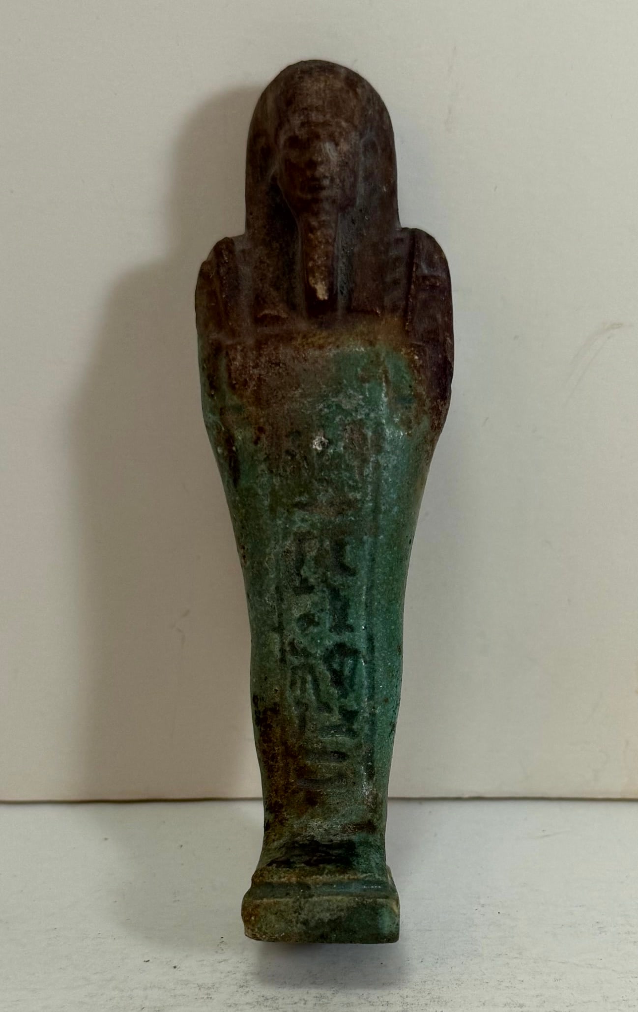 Important Ancient Egyptian Faience Ushabti: Modeled with impressed hieroglyphics down the front legs. Height: 4 3/4 inches, Width: 1 1/2 inches, Depth: 1 inch. Weight: 2.6 oz.