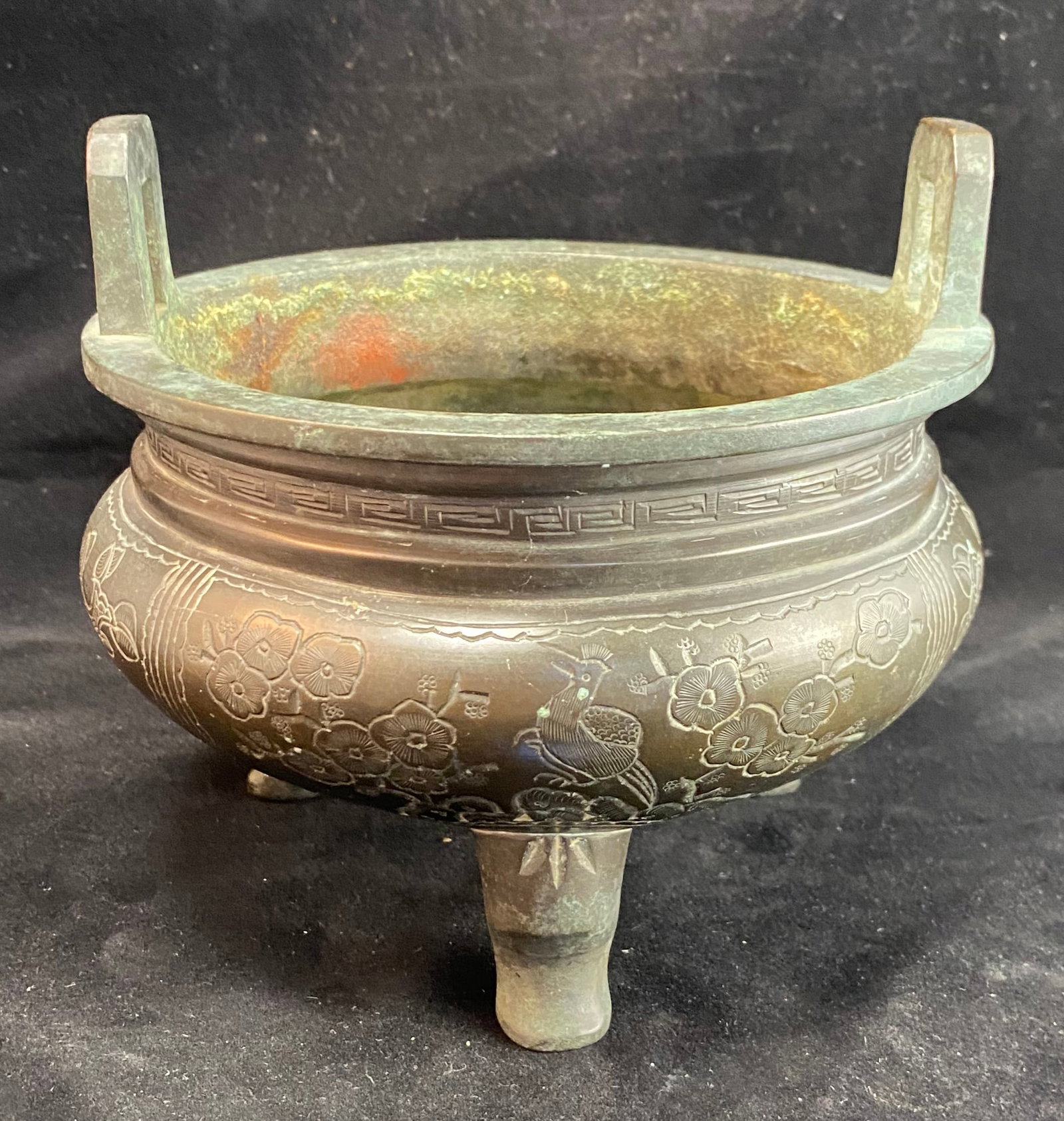 Chinese Bronze Tripod Censer, Four Character Mark: The censer decorated with plum blossoms, peony and pomegranate, the underside cast with a four character mark. Height: 5 1/2 inches to the top of the handles, diameter: 6 inches. Weight: 2 lbs. 14 oz.