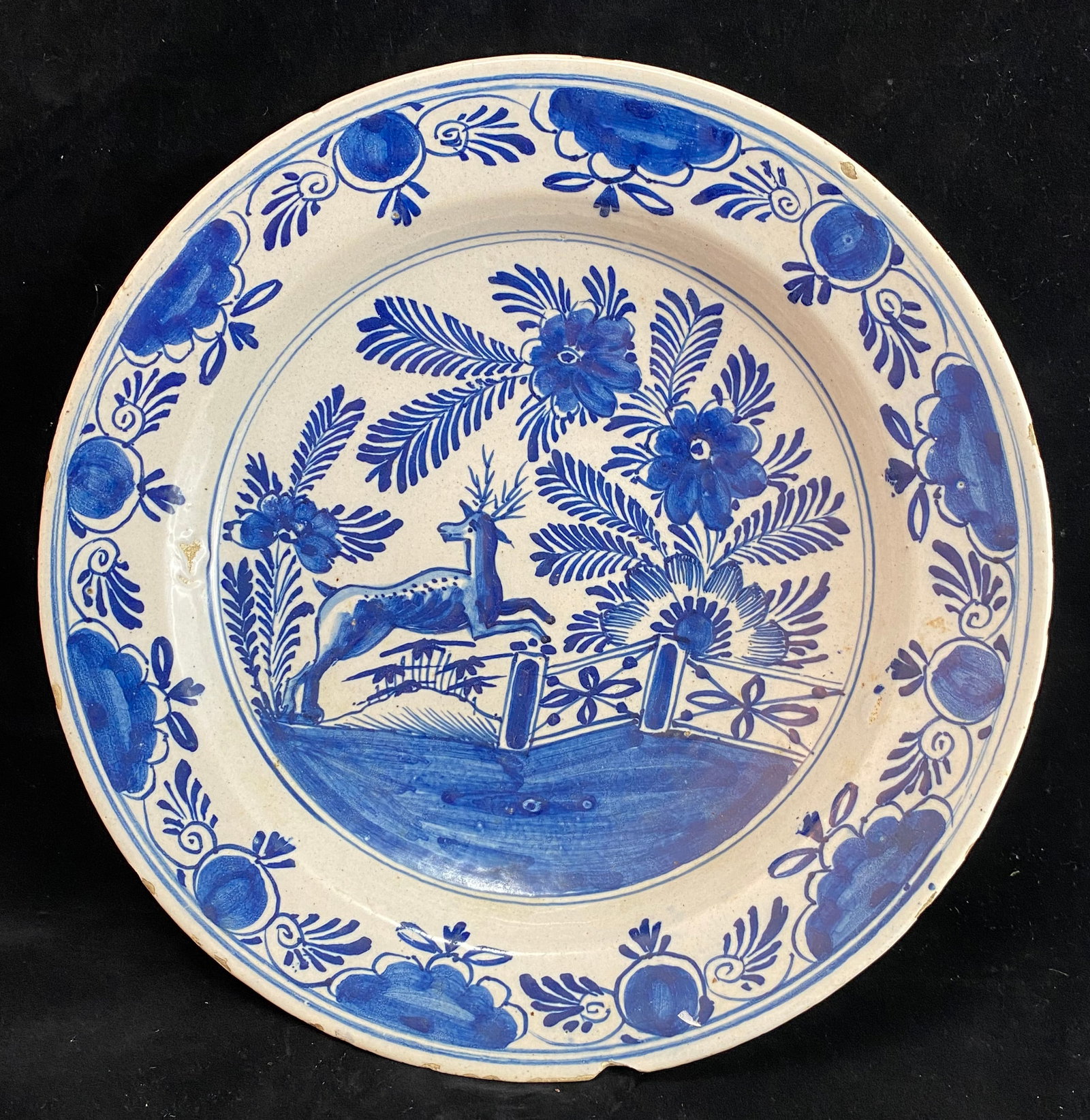 Dutch Delft Blue and White Faience Charger or Dish, 18th Century: With a deer in a garden amongst flowering plants. Diameter: 12 inches, Height: 2 1/4 inches. Weight: 2 lbs. 4 oz. This item is at our New York location.