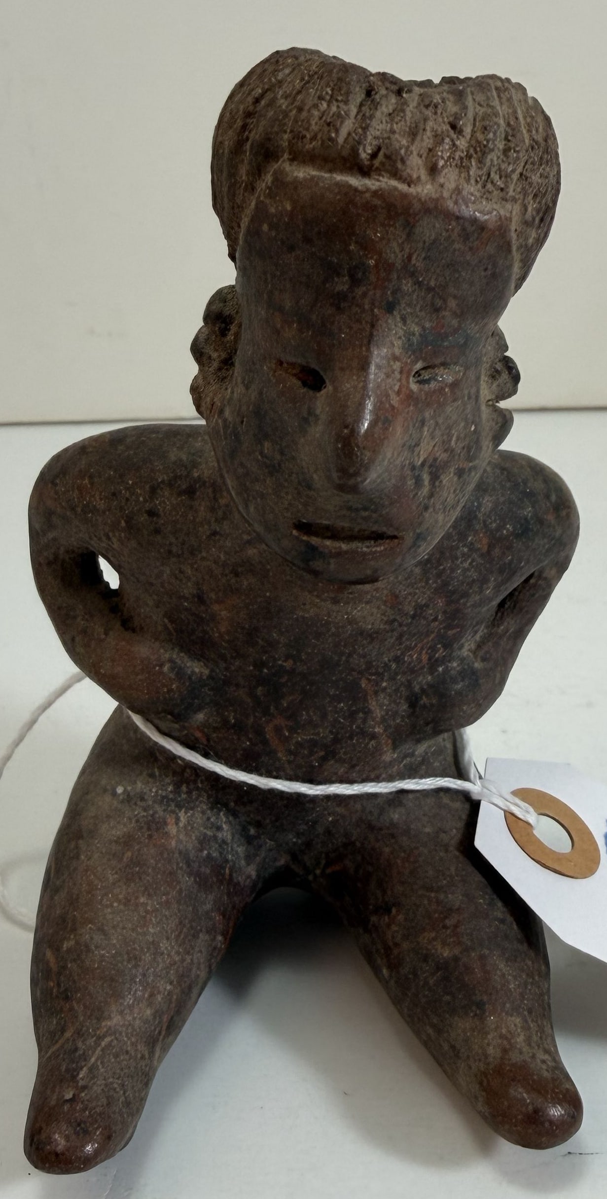 Pre-Columbian Nayarit Pottery Seated Figure: Height: 4 1/2 inches, Width: 2 3/4 inches, Depth: 3 inches. Weight: 6 oz. This item is at our New York location.