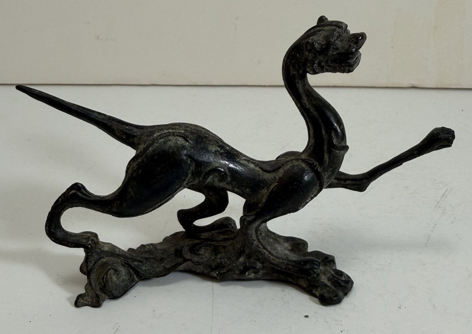 Chinese Bronze Figure of a Dragon: The dragon with elongated limbs and sculpted leaping through the cloud form base. Length: 4 3/4 inches, Height: 3 inches, Depth: 1 1/4 inches. Weight: 7.5 oz.