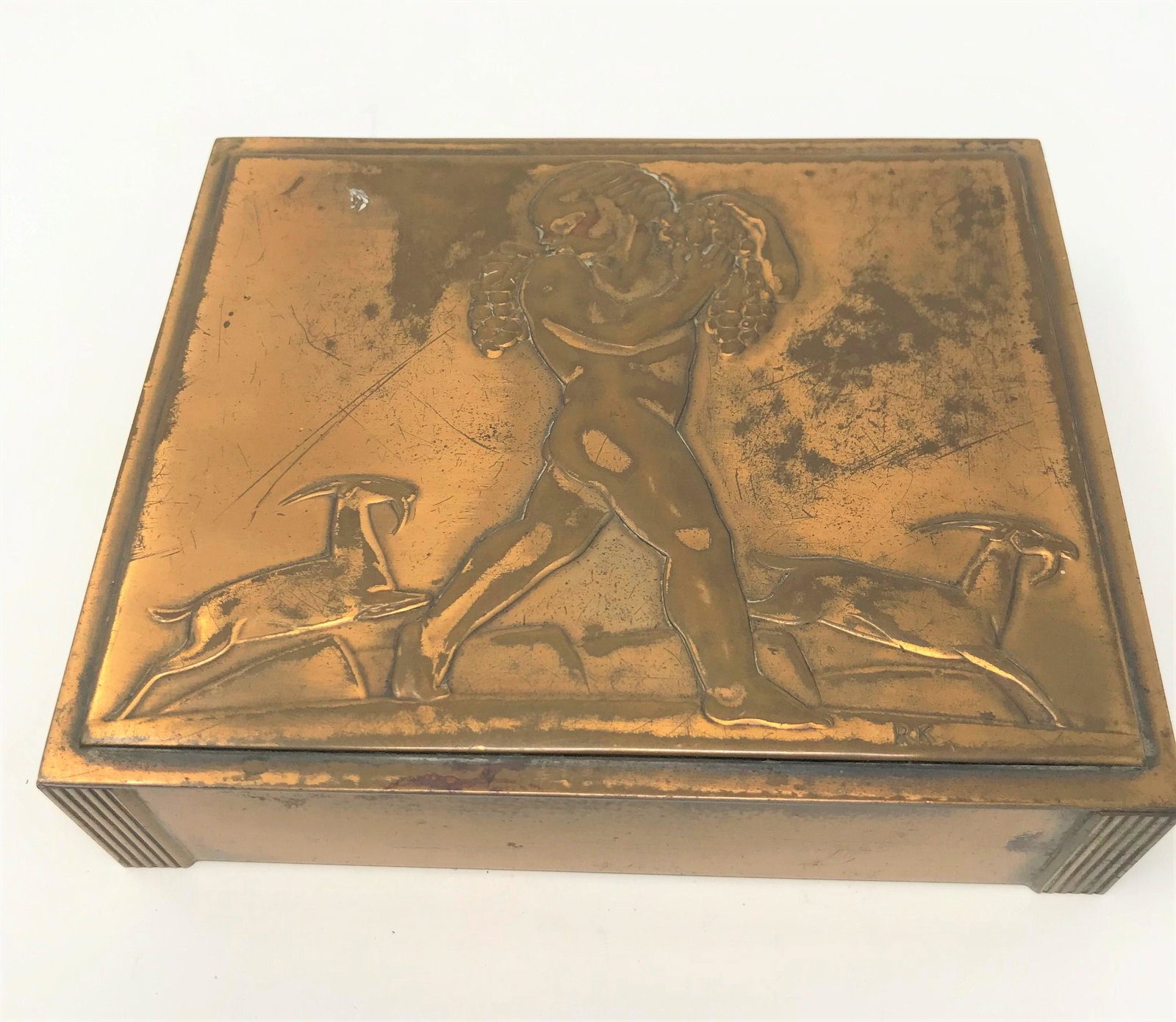 Rockwell Kent for Chase Brass & Copper Co. - Art Deco Bacchus Cigarette Box: A rare Art Deco cigarette box in copper or bronze with wood interior. This large and heavy box is decorated on its lid with a young "Bacchus" figure carrying two large bunches of grapes, and with two