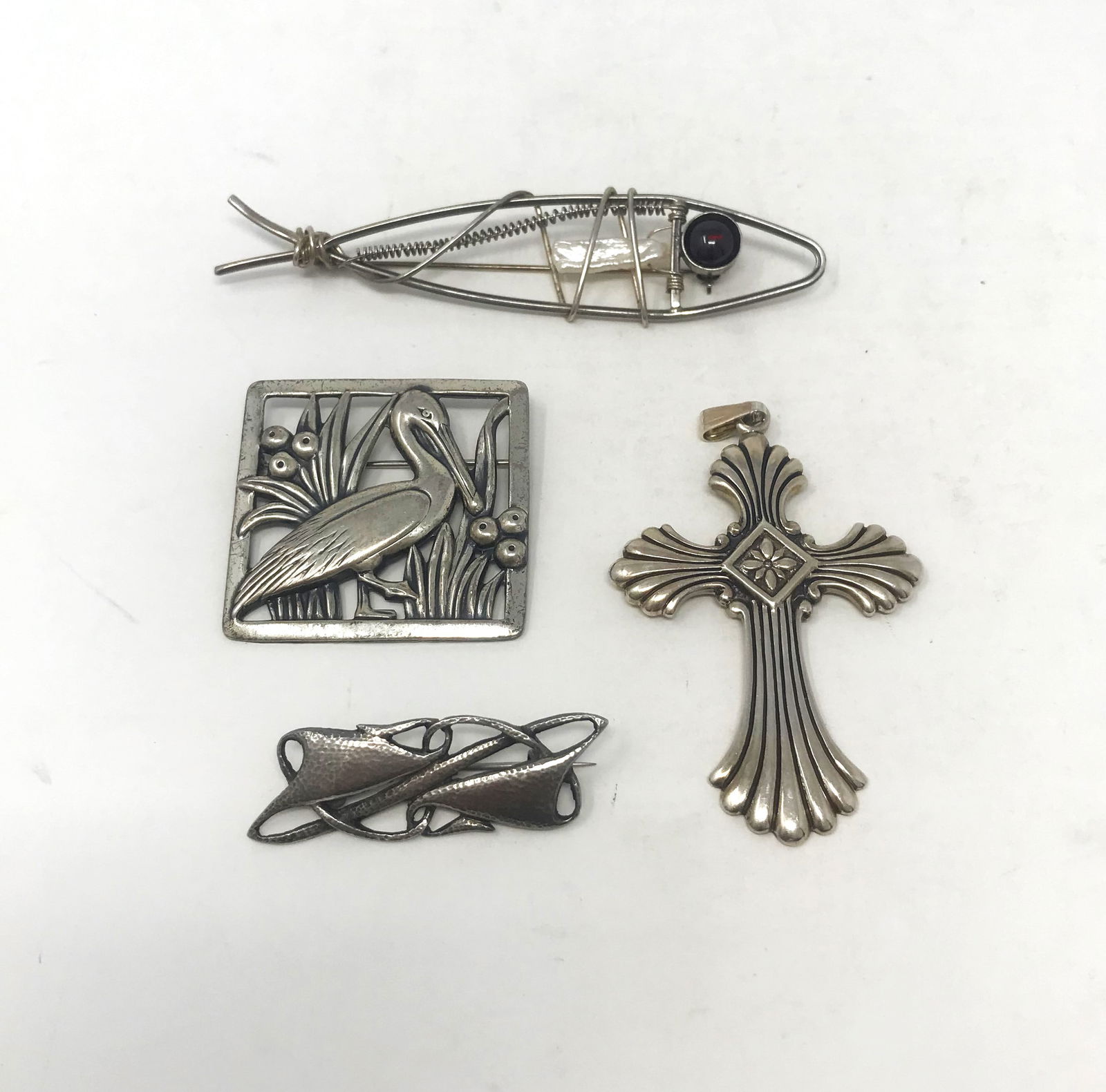 Collection of Four (4) Vintage Silver Jewelry Pieces.: A collection of four silver jewelry pieces including three brooches and one necklace pendant. Brooches include: a "Norseland" by "CORO" pin of an Ibis in a wetland landscape, pierced design, size 1 11