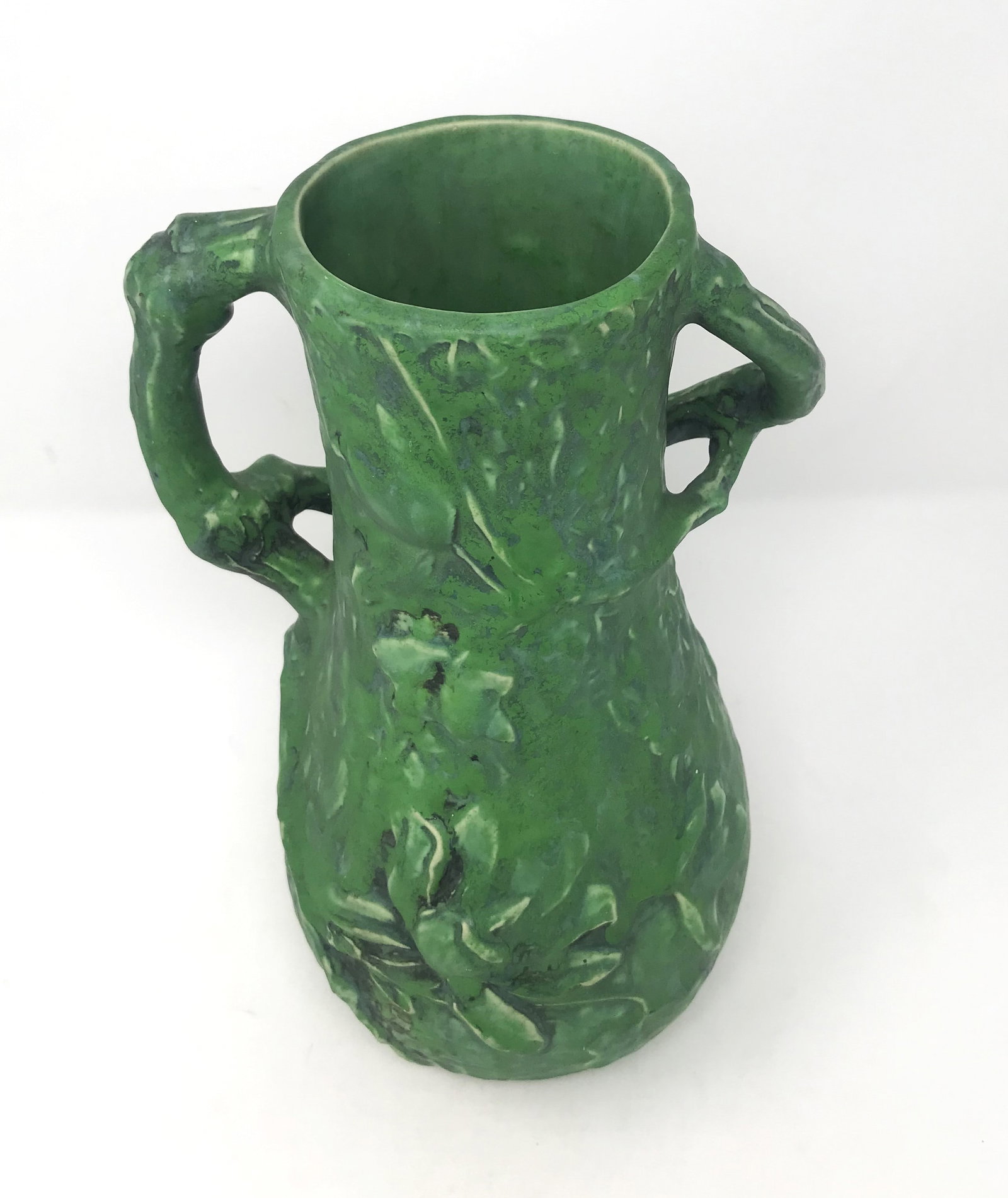 A large Weller Pottery Vase with Applied Handles.: An exceptional Weller vase with applied handles made as twisted branches and with high relief floral decorations on each side, with a coppertone type glaze (we have seen this glaze listed as experimen