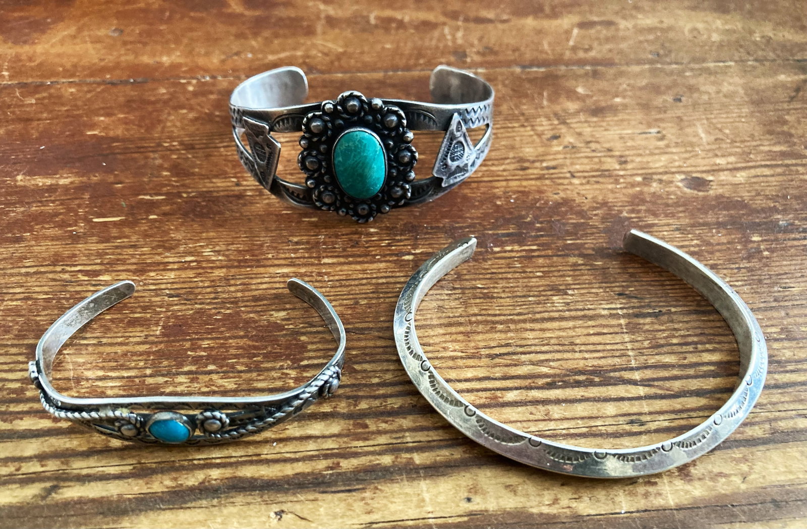 Collection of Three (3) Navajo Sterling Silver Cuffs, c. 1950's.: A collection of three Navajo Sterling silver cuffs. The first, an ingot silver cuff with stamped design, unmarked, size: 5 3/4 in. with a 1 1/4 in. opening, circa 1960. The second, a Fred Harvey style