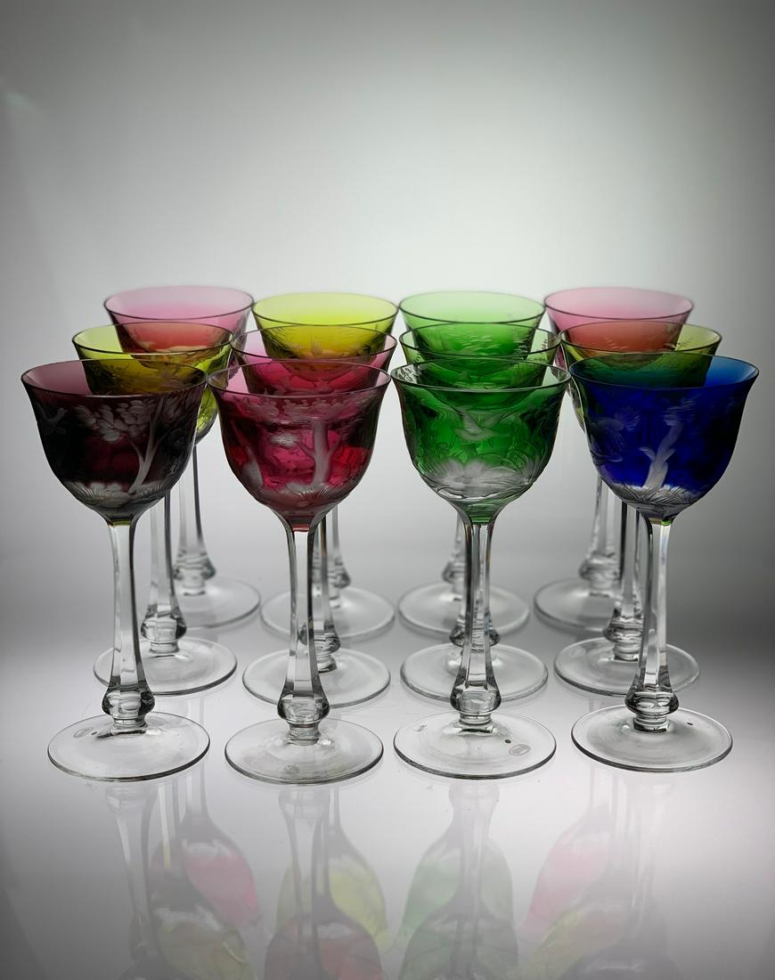Set of 12 Multicolor Signed Moser Engraved Hock Wines: This set of 12 are all signed Moser. They have copper wheel engraved different scenes, including duck, squirrel, and pheasant. Colors are chartreuse, green, cranberry, cobalt and purple. Second half o