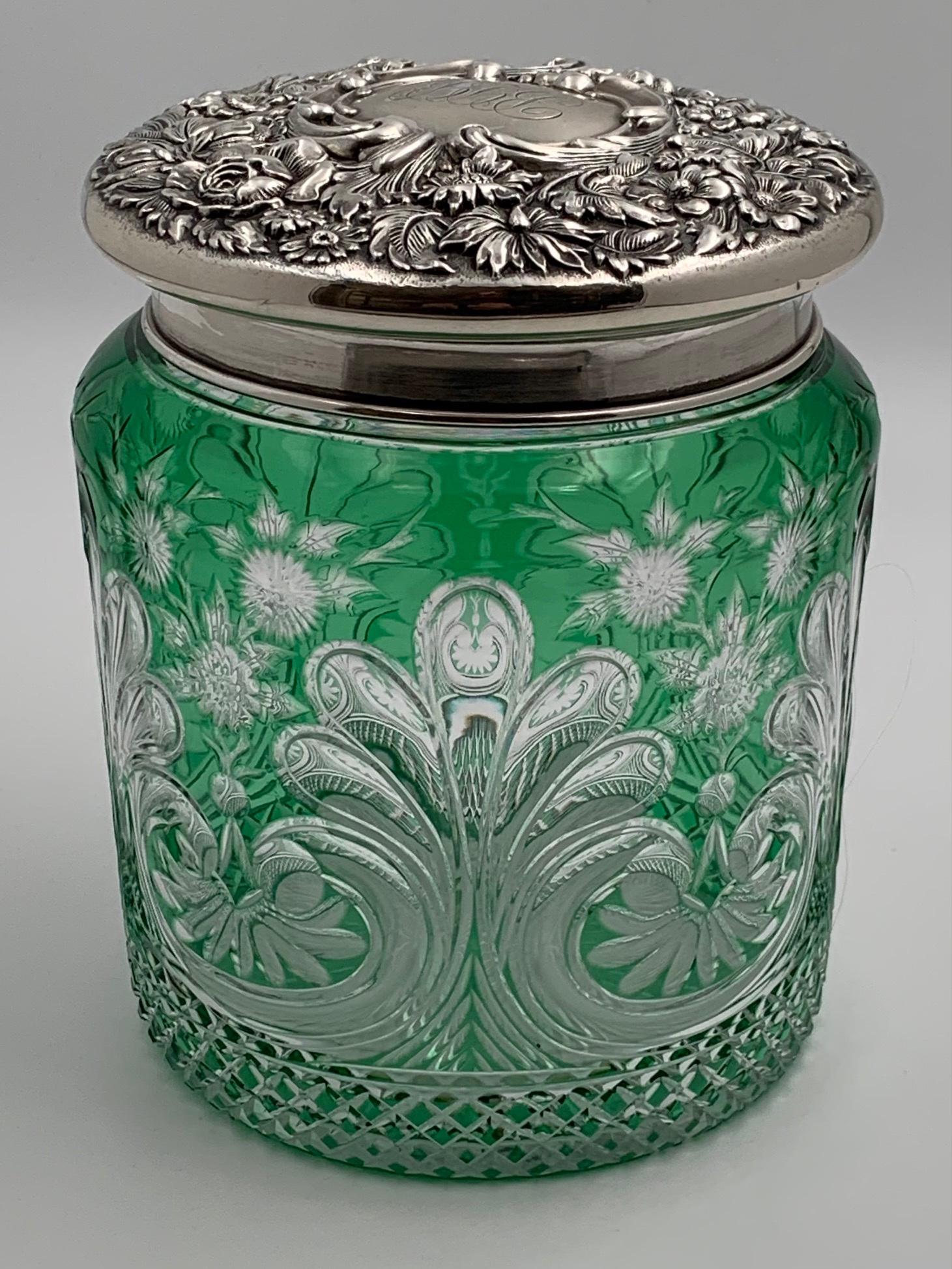 Stevens & Williams Cut Glass Green Humidor Sterling Lid: Beautiful green to clear cut glass humidor by Stevens & Williams. Has a great repousse sterling lid by Theodore B. Starr, NY. Lid fits snug. Circa 190. Dimensions: 7" h. x 5 1/2" dia.