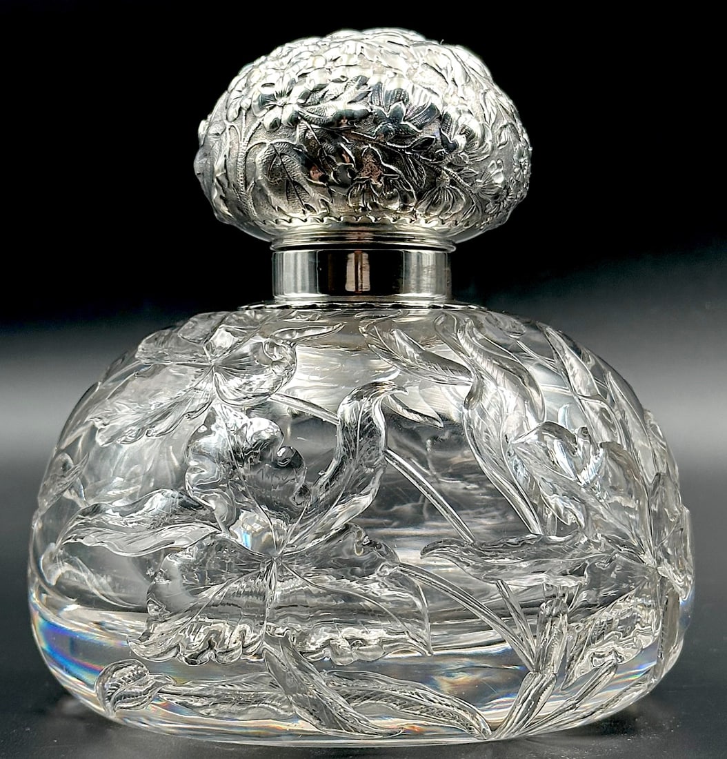 Large Intaglio Cut Glass Inkwell Sterling Lid: This American Brilliant cut glass inkwell is quite large. It is round with an intaglio cut realistic floral design. The sterling mount has a floral repousse motif and the lid is hinged. This is a heav