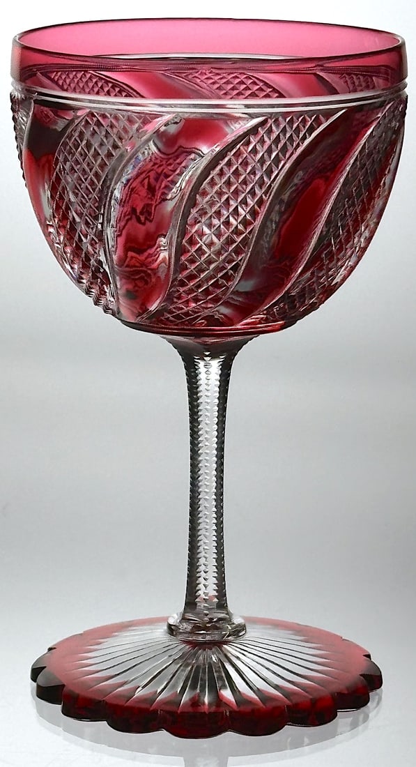 Beautiful Red To Clear Wine Stem In Spiral: This beautiful wine stem has a deep red color cut to clear. The bowl is cut in a spiral design with swirled tusks and crosshatching. The foot is also red and has a scalloped edge with a rayed star on 