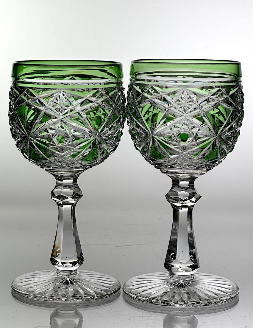 Two Signed Baccarat Cut Glass Wine Stems Green To Clear: A pair of green cut to clear wine stems by Baccarat. The bowl has a solid green band at top with crossed miters , stars and two fans below. The pyramid stems are flulted with a faceted knob. The base 