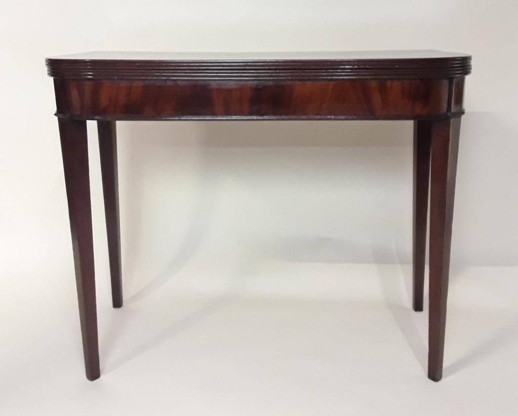 REGENCY MAHOGANY GAMES TABLE: English, circa 1820 Flip-top with swing legs, blue cloth playing surface. Tapered legs 29" h x 36"w x 18"d closed and 36" square when open