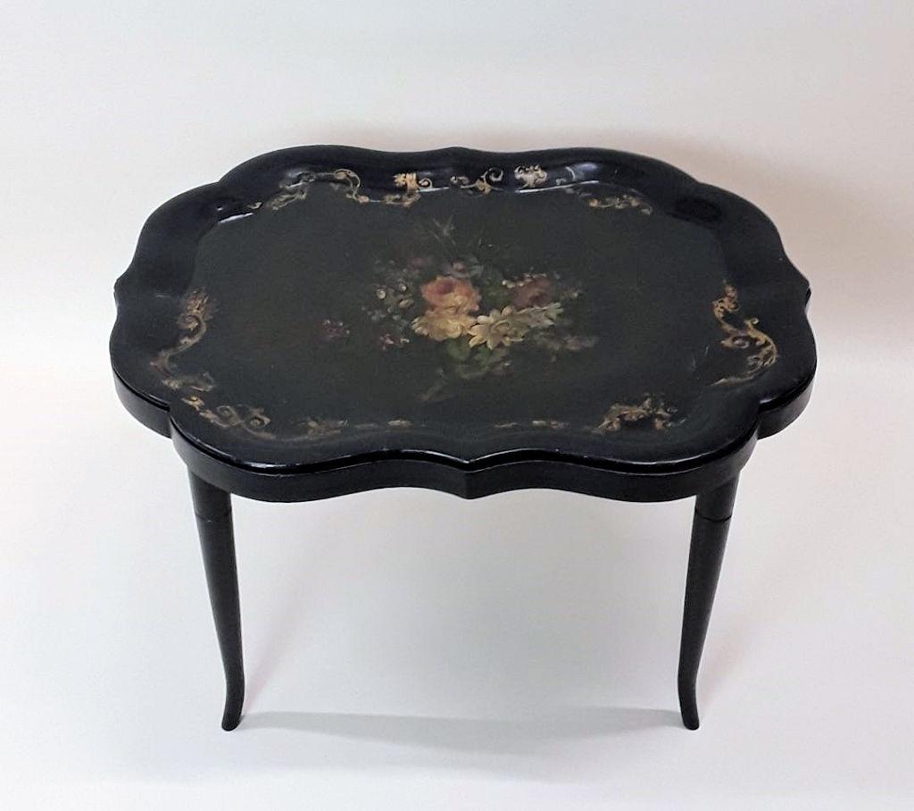 VICTORIAN PAPIER MACHE TRAY ON STAND: English, late 19th century Lovely painted floral centre with foliate scrolls along the lipped edge. 18" h x 30.5 " w x 23" d Stand appears original. Old repair to tray.