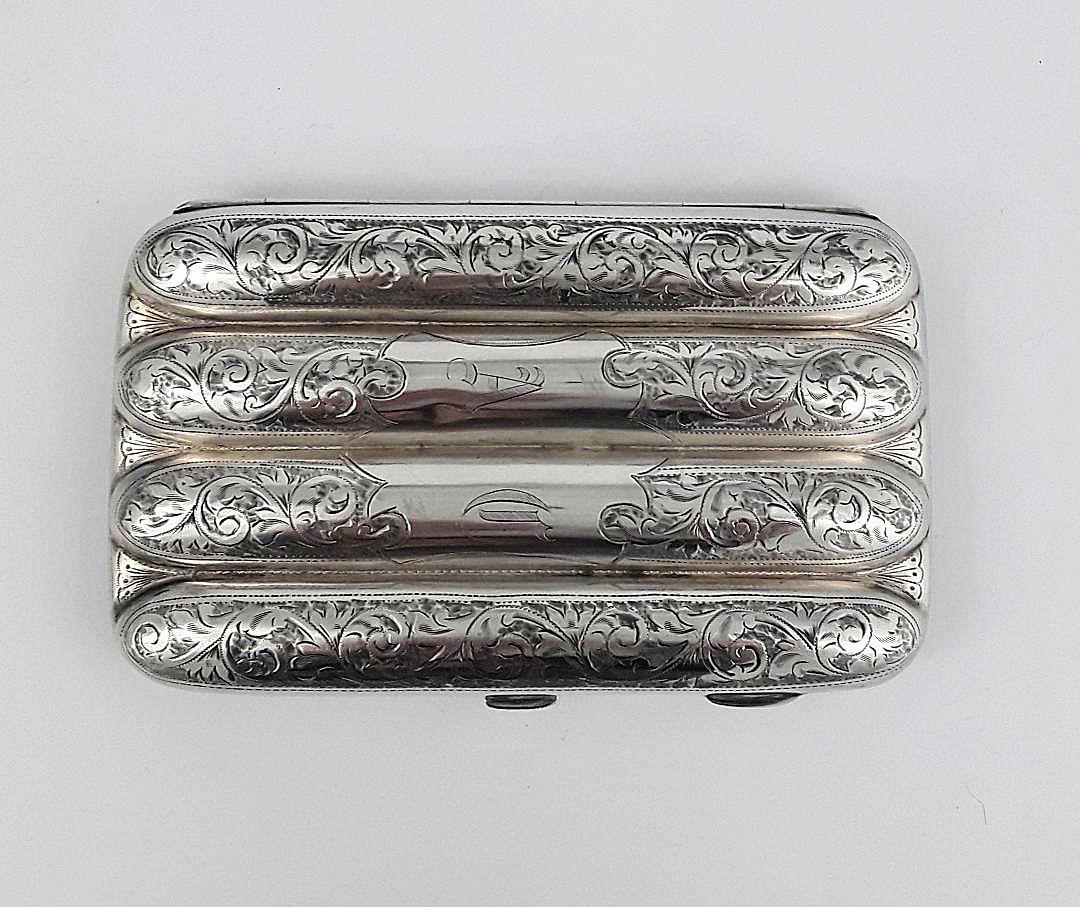 EDWARDIAN STERLING SILVER CIGAR CASE: English, Birmingham, circa 1910 Maker: Williams Attractive four cigar/cigarello silver case having a hand- engraved body with a foliate scroll design and vermeil interior. 158 grams 5" x 3"