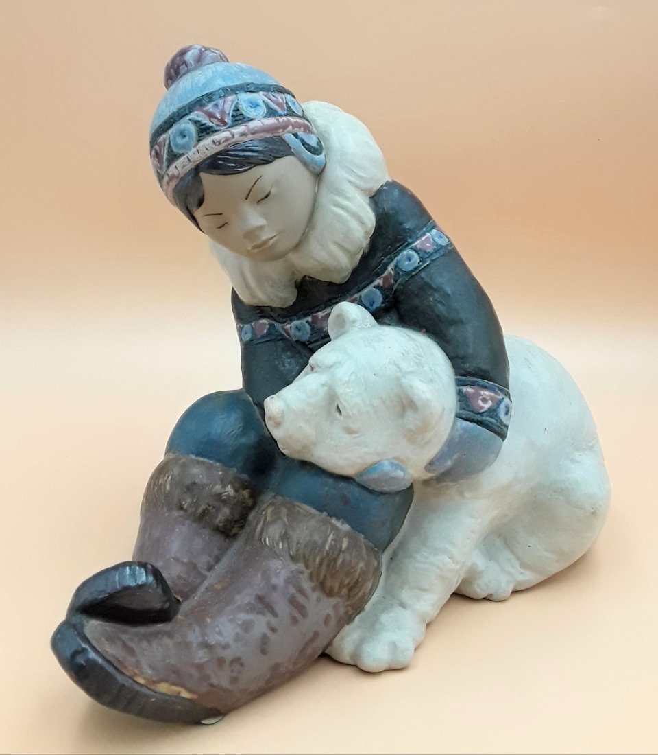 LARGE LLADRO FIGURINE, INUIT BOY WITH BEAR CUB: Spain, circa 1970s Charming figure of an Inuit child hugging a polar bear cub #2097 Polychrome gres porcelain and in excellent condition 9" h x 7" w x 10.5" d