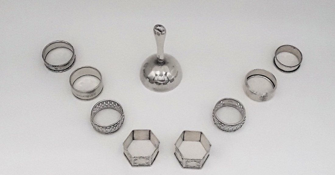NINE PIECE LOT OF STERLING SILVER ITEMS: Mid 20th century, mixed dates and makers Comprising 8 napkin rings and a dinner bell. 118 grams total weight