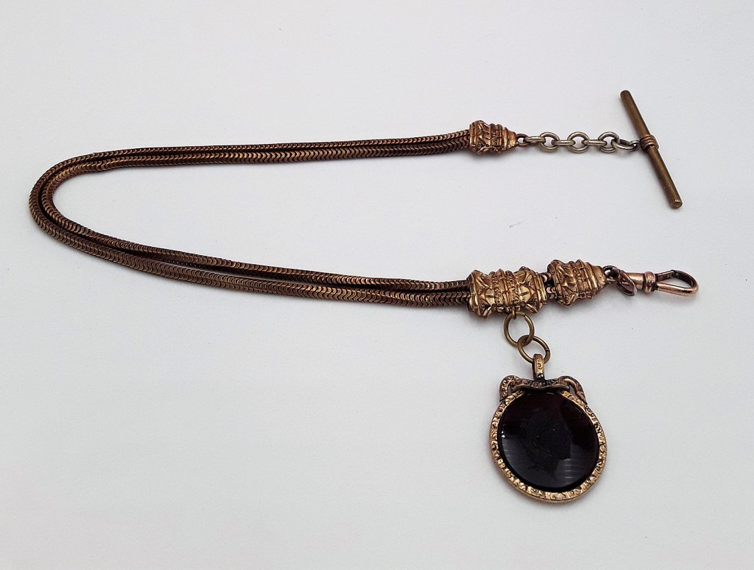 ANTIQUE WATCH CHAIN AND INTAGLIO FOB: Late 19th / early 20th century Gold filled snake link chain having a stone fob with a recessed engraving of a head in profile. 13" long