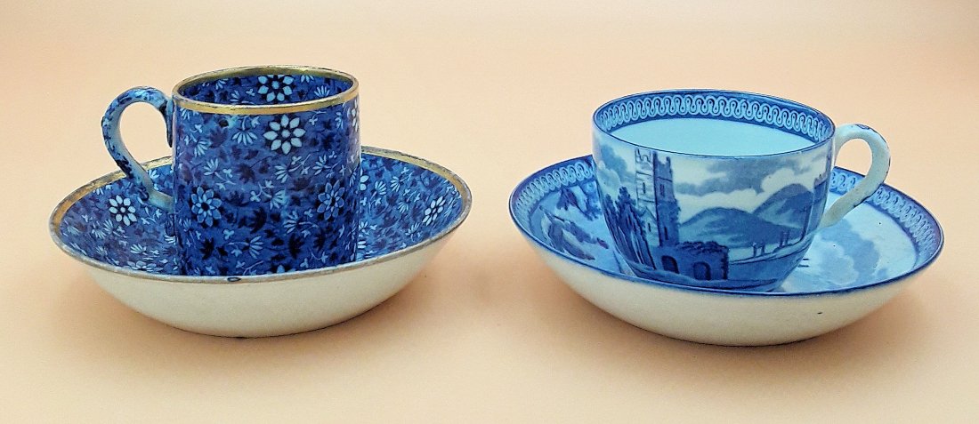 TWO 19TH CENTURY ENGLISH CUPS AND SAUCERS: Two 19th century blue and white English cups and saucers, one having a daisy pattern, 2.5" x 3.25" diameter of saucer and the other having figures in a landscape with a church and castle, 1.75" x 4" d