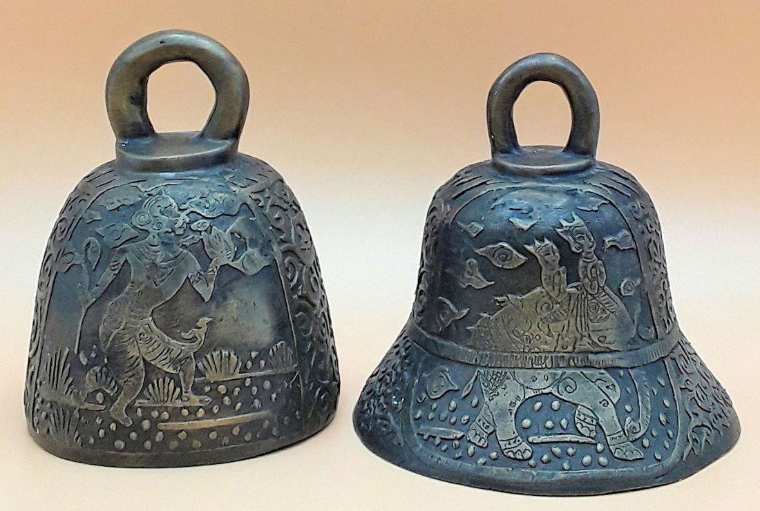 ANTIQUE BRASS BUDDHIST BELLS: Two old Buddhist tantric bells cast in brass, one depicting deities riding an elephant and the other of a deity surrounded by flowers. One bell is missing its clapper. 6"x4.5", and 5.5"x5.5"
