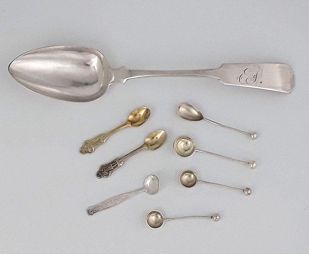 STERLING SILVER SPOON GROUPING: Comprised of a 9" dessert spoon; American, Philip Heart Furman active, 1821 - 1842 Schenectedy, New York in a plain fiddle design handle; along with 7 salt spoons having mixed makers and dates. 84 gra