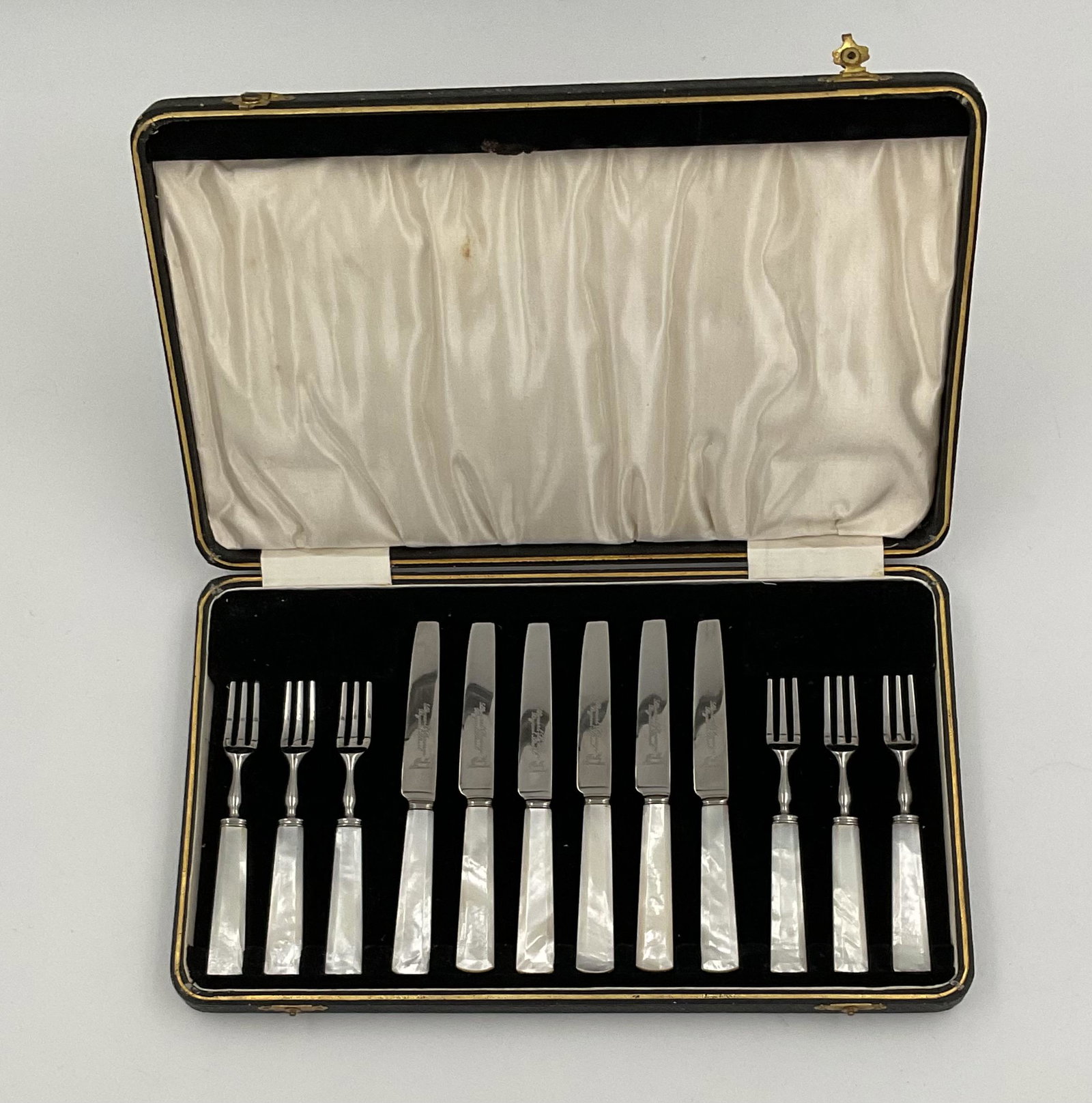 CASED SET OF FRUIT FORKS AND KNIVES: British, circa second quarter 20th century Retailed by Stewart Dawson Mother-of-pearl handled fruit or dessert knives and forks for six in the original case. Very good condition
