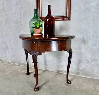 MID 18TH CENTURY MAHOGANY GAMES TABLE: Probably Irish, circa 1750 An 18th century games/tea table with gateleg cabriole legs Great old finish and gate leg converts the demi-lune table to a circular table. Includes a compartment for