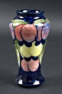 MOORCROFT WISTERIA WITH PLUMS VASE: England circa 1940s Hand painted yellow, blue and plum fruit on a deep blue ground. 7.25" h x 4"w