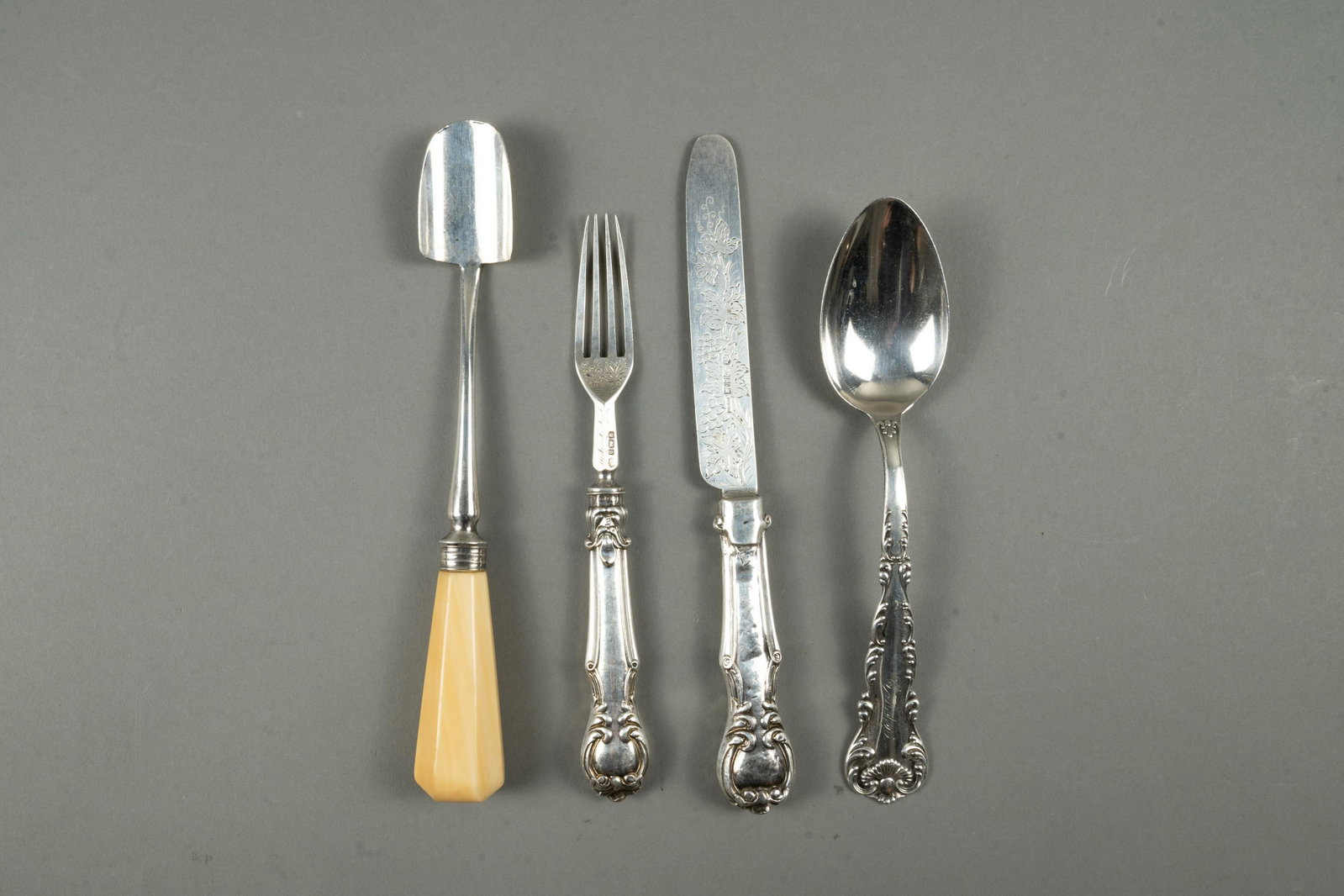 SILVER DINING PIECES: Four sterling silver dining pieces including a cheese scoop, an oval spoon that is believed to have belonged to Frederick Carder and a Sheffield fruit knife and fork with sterling blade and tines the 