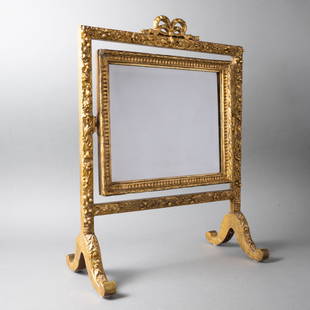 ANTIQUE GILTWOOD DRESSING MIRROR: Possibly French, late 19th - early 20th century A fine lady's table dressing or vanity mirror with a winding floral motif. Swivels between two upright columns. Later bevelled mirror. 22" x 16.5" x 