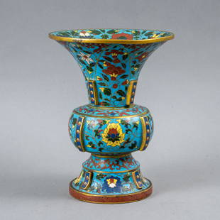 CHINESE CLOISSONE GU-FORM VASE: A finely made Chinese cloisonne enamel gu-form vase with a floral and foliate design on the outside rising to a trumpet neck and having upright gilt plantain leaves inside the mouth. Height 7.25"