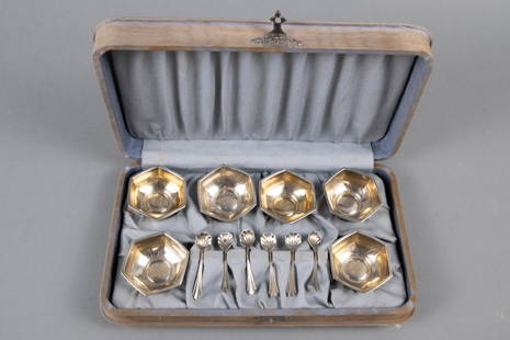 CASED SET OF SALT CELLARS: An early 20th century set of six hexagonal sterling silver salt cellars and spoons. In original fitted case. Fading to fabric. 65.2 grams.