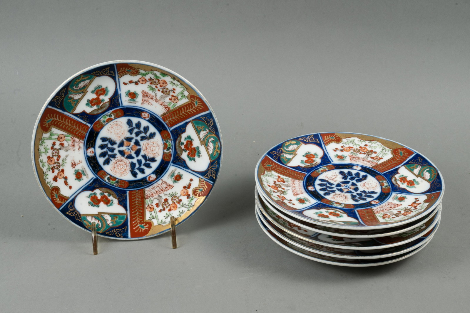 ANTIQUE IMARI PLATES: Japan, early 20th century. A set of six classic Imari design luncheon size plates, one having a hairling crack. Backstamped "Made in Japan". 7.5" diameter