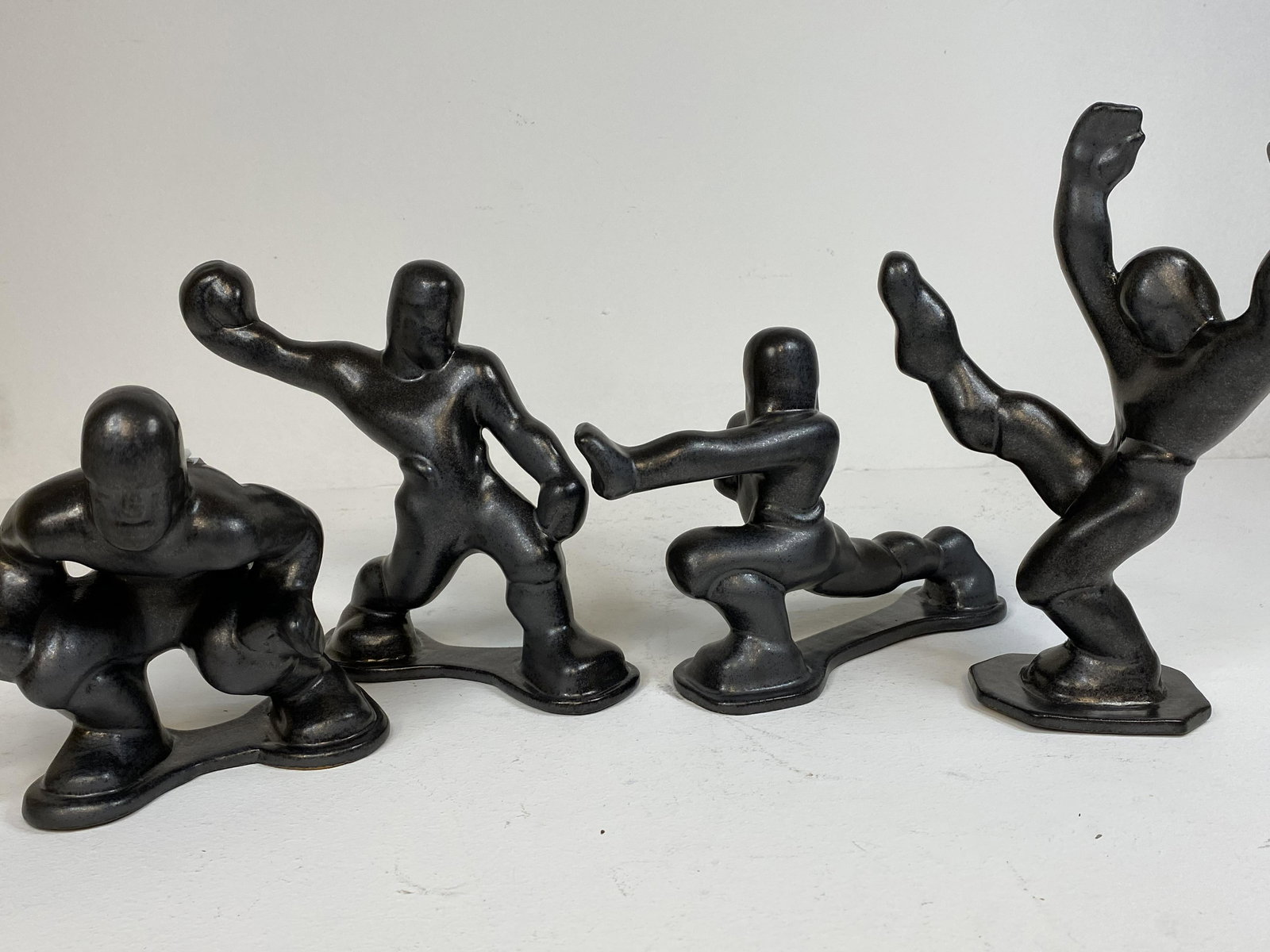 Shearwater Pottery: Rare Football team. 4 piece set in a gunmetal grey glaze. Tallest 9 5/8"