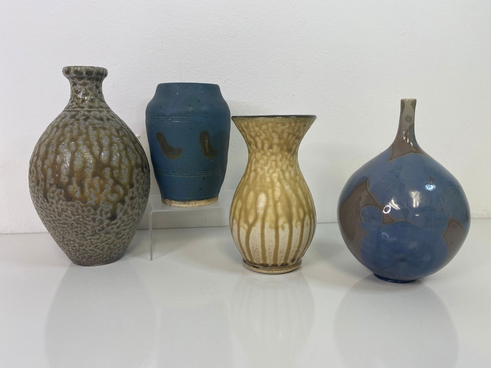 4 Studio Pottery Lot: 4 pieces total including a Stoneware bottle form measuring 7 1/4". Good crystalline weed pot and another drip glaze and a blue studio pot dated 1955