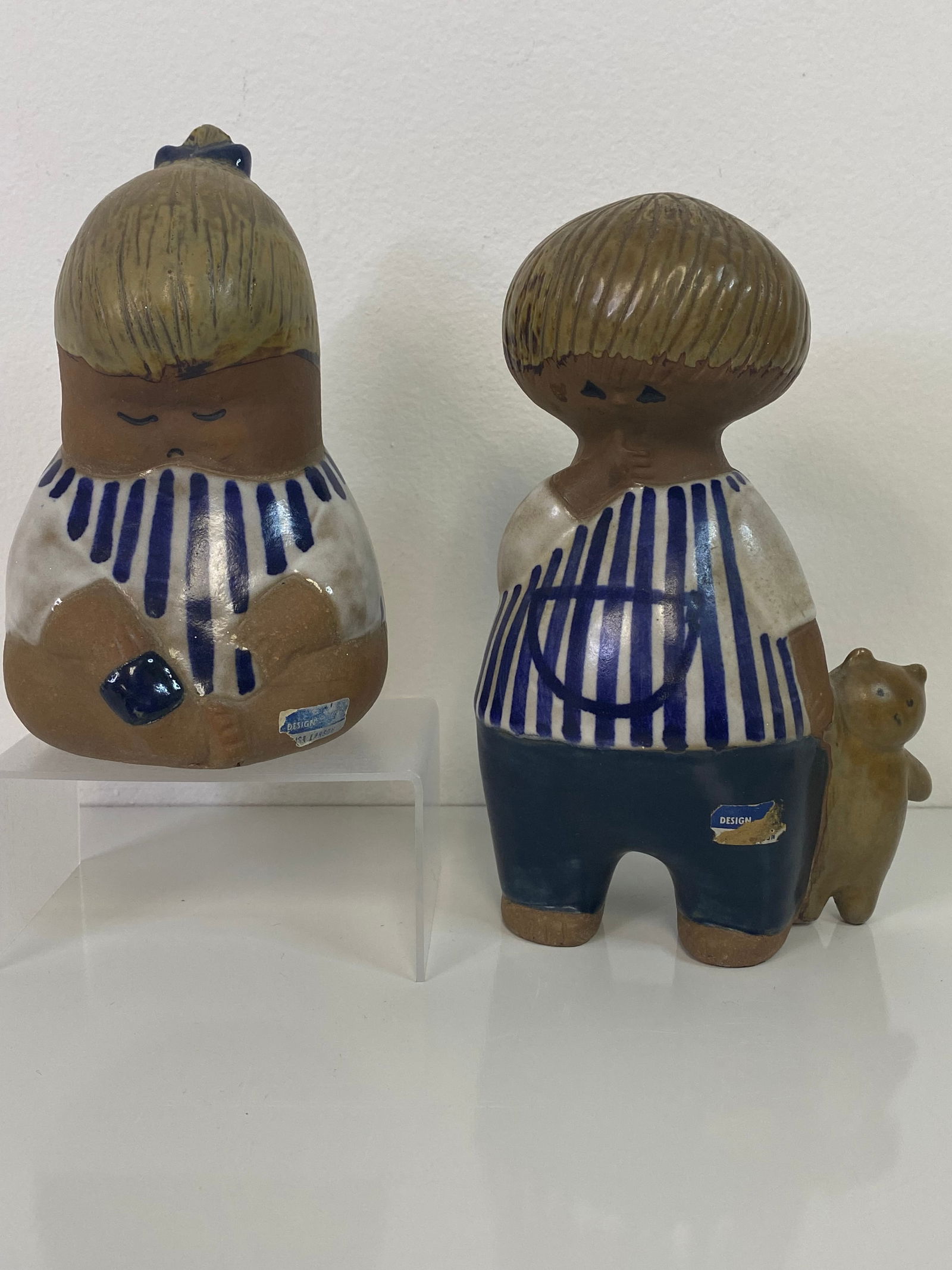 2 pcs Lisa Larson for Gustavberg Sweden: 2 pieces Children of the Worl 1st is a girl with a teddy bear and the other just sitting. The tallest is the boy holding Bear at 7 1/2" tall. Partial label on both along with the proper signatures