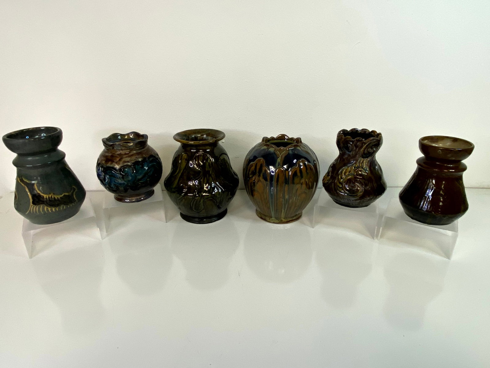 Moller And Bogely Grouping: 6 pcs in this lot consisting of the tallest at 6 1/2" tall in browns and greens , 2 cabinet vawesw one blue, one brown with similar designs of Waves crashing , 2 other vawses and the 2nd to the
