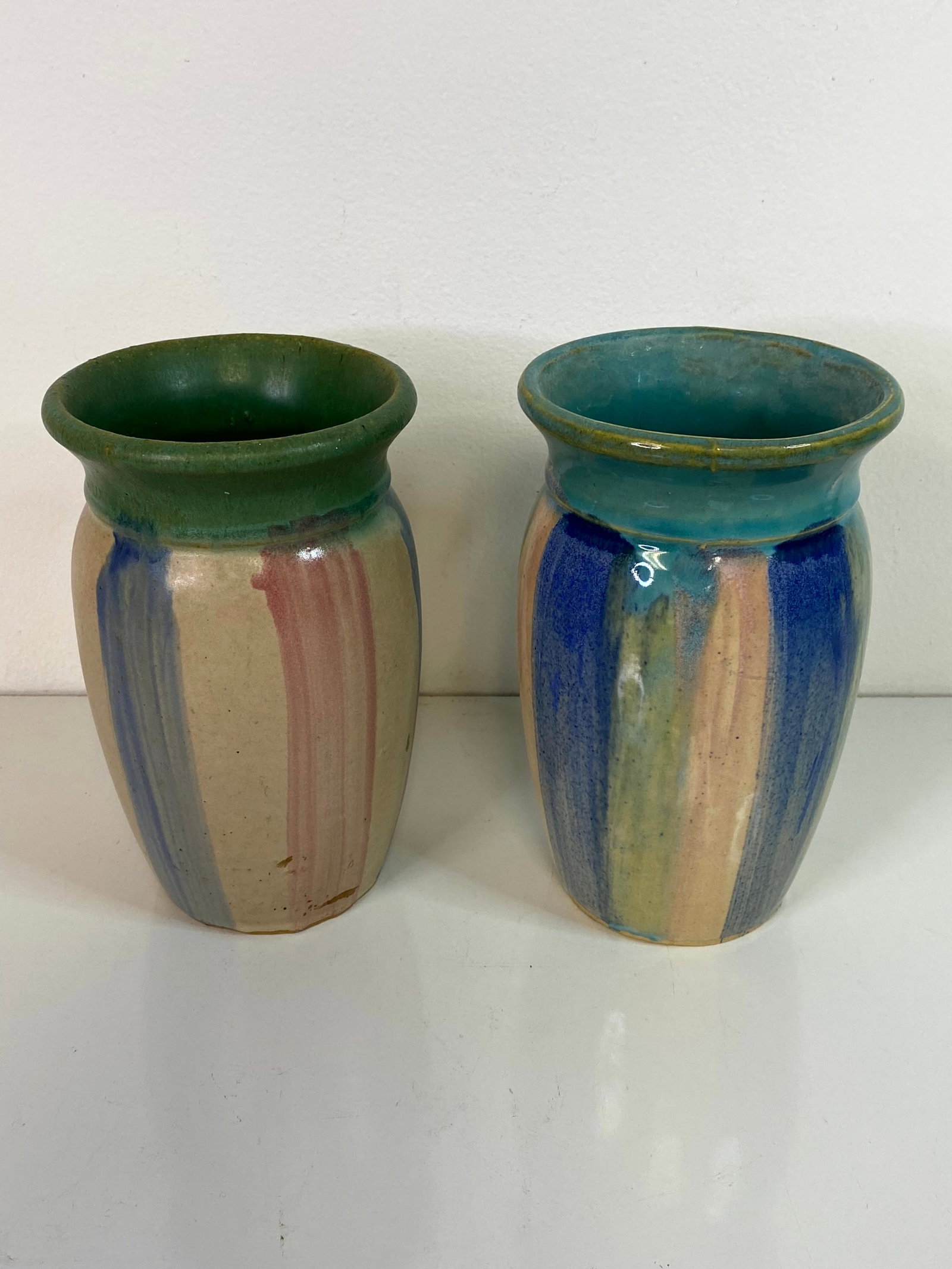 Pair Early Hull Pottery: this vase stands 8" tall with vertical color of blue and pink with a green top and tan underglaze.