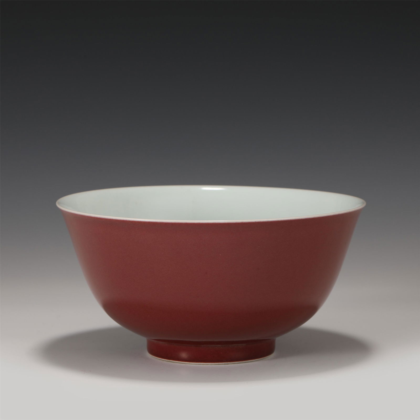A CHINESE RED GLAZED PORCELAIN BOWL: A CHINESE RED GLAZED PORCELAIN BOWL 19 cm Diam x 10 cm H x Weight 520 gram. This bowl has a mouth, a deep belly and circled feet. Tall and handsome. The outer wall is applied with red glaze, with pure