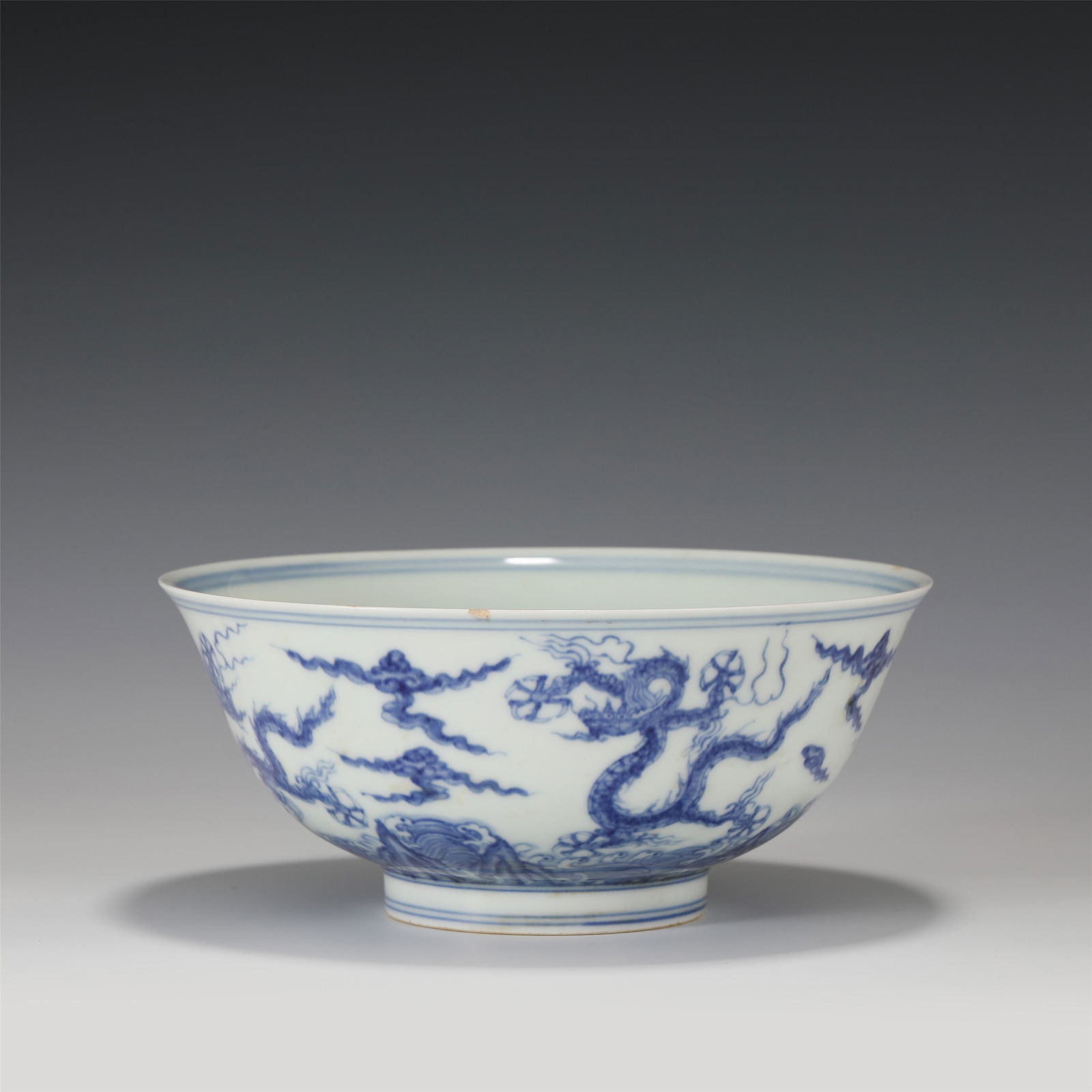 A CHINESE BLUE AND WHITE PORCELAIN DRAGON PATTERN BOWL: A CHINESE BLUE AND WHITE PORCELAIN DRAGON PATTERN BOWL 19 cm Diam x 8 cm H x Weight 420 gram. The bowl is round and upright, open, arc belly, and bears the ring feet. The bowl body is painted with blu