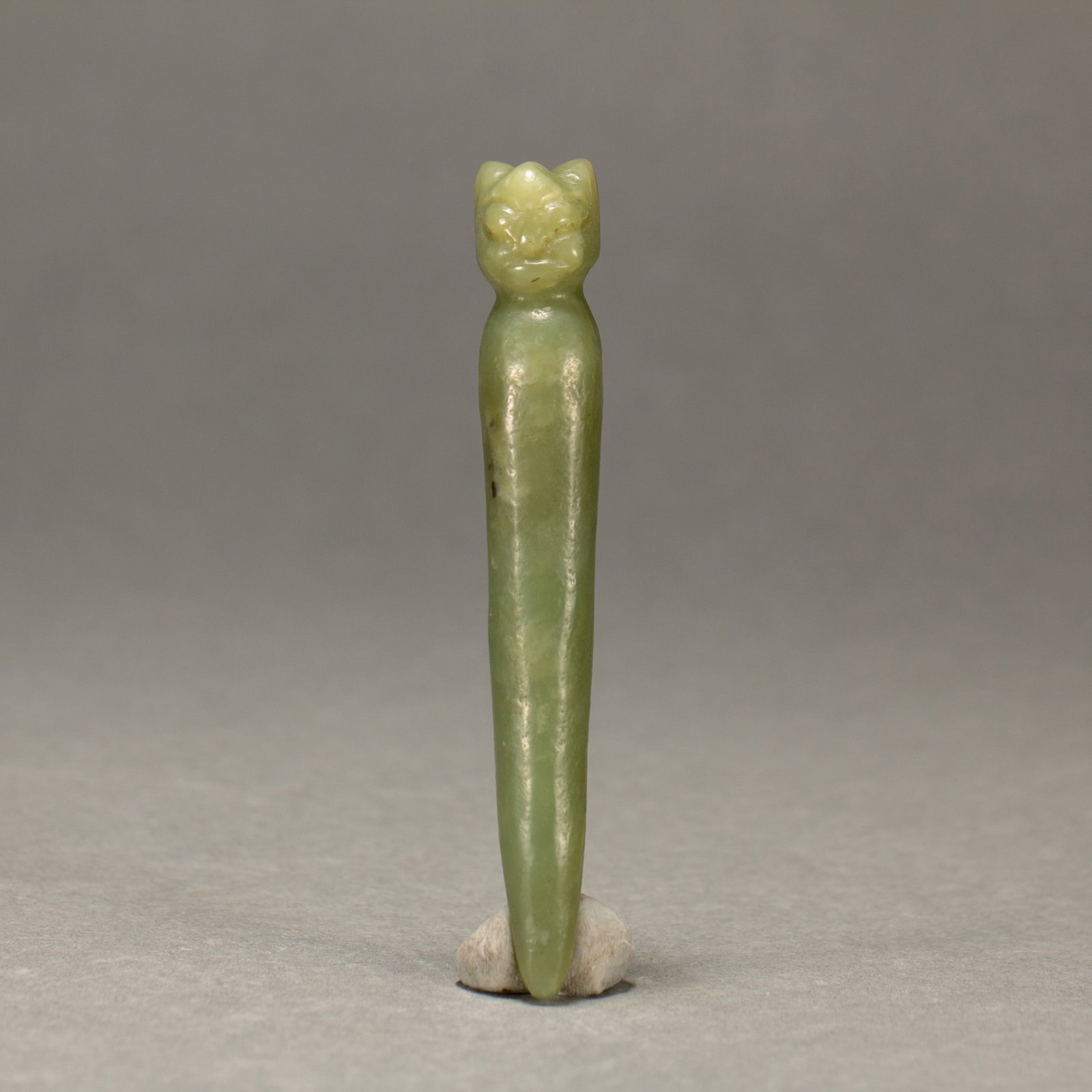 A CHINESE CARVED JADE BI: A CHINESE CARVED JADE BI L. 9.5 cm. Weight 30 gram. An ornament carved in jade. The top is carved into the shape of an animal head, and the whole is light yellow green.