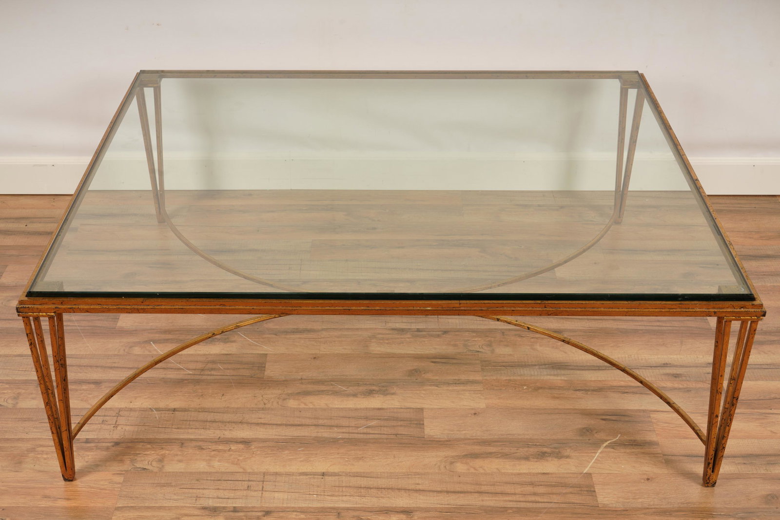 Gilt Metal Contemporary Glass Top Coffee Table: One (1) Coffee table with glass top and modern design. H 16" x W 47 1/2" x D 42".