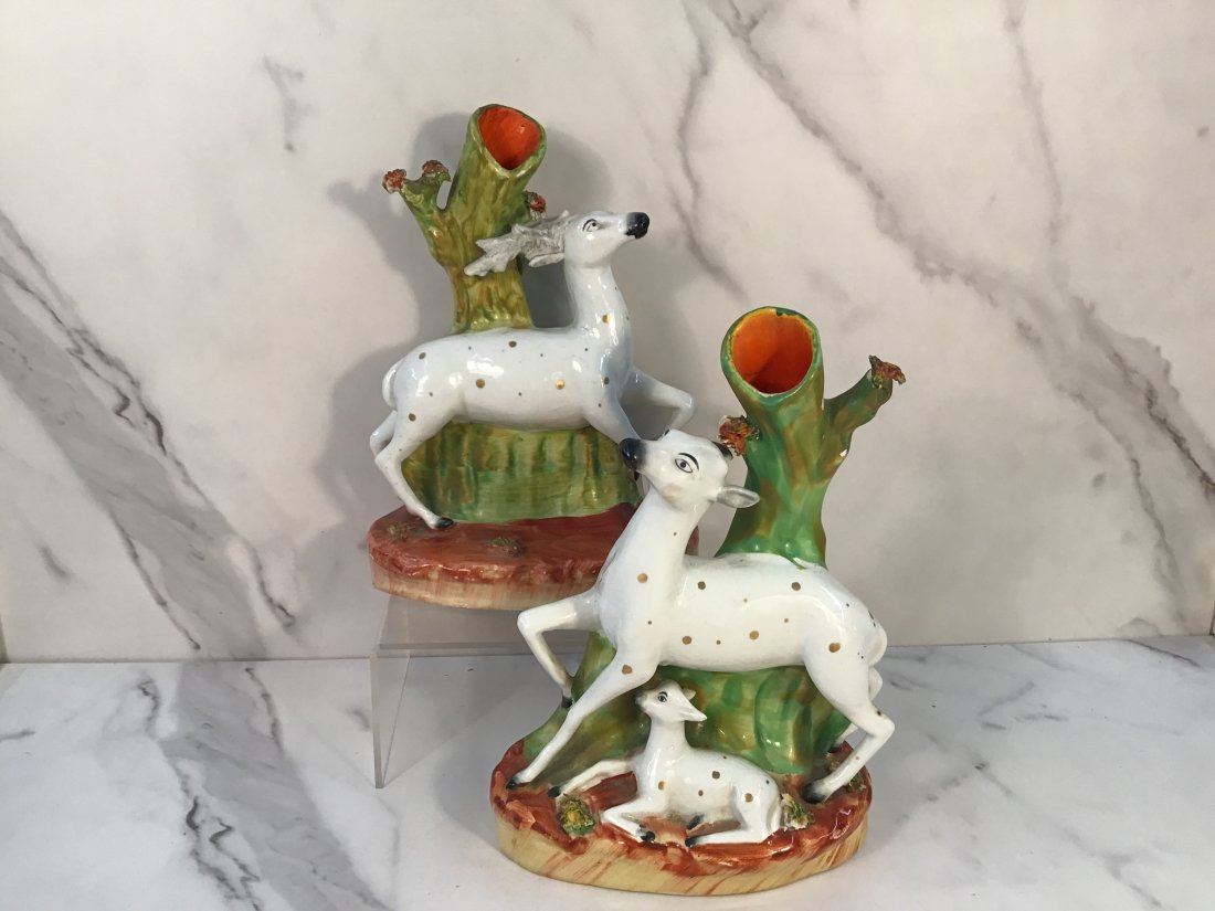 Pair English Staffordshire Deer Family 7.75" Spill Vases: A festive grouping of a deer family raised on oval bases in a landscape with coleslaw accents. Some painted glaze flaking.